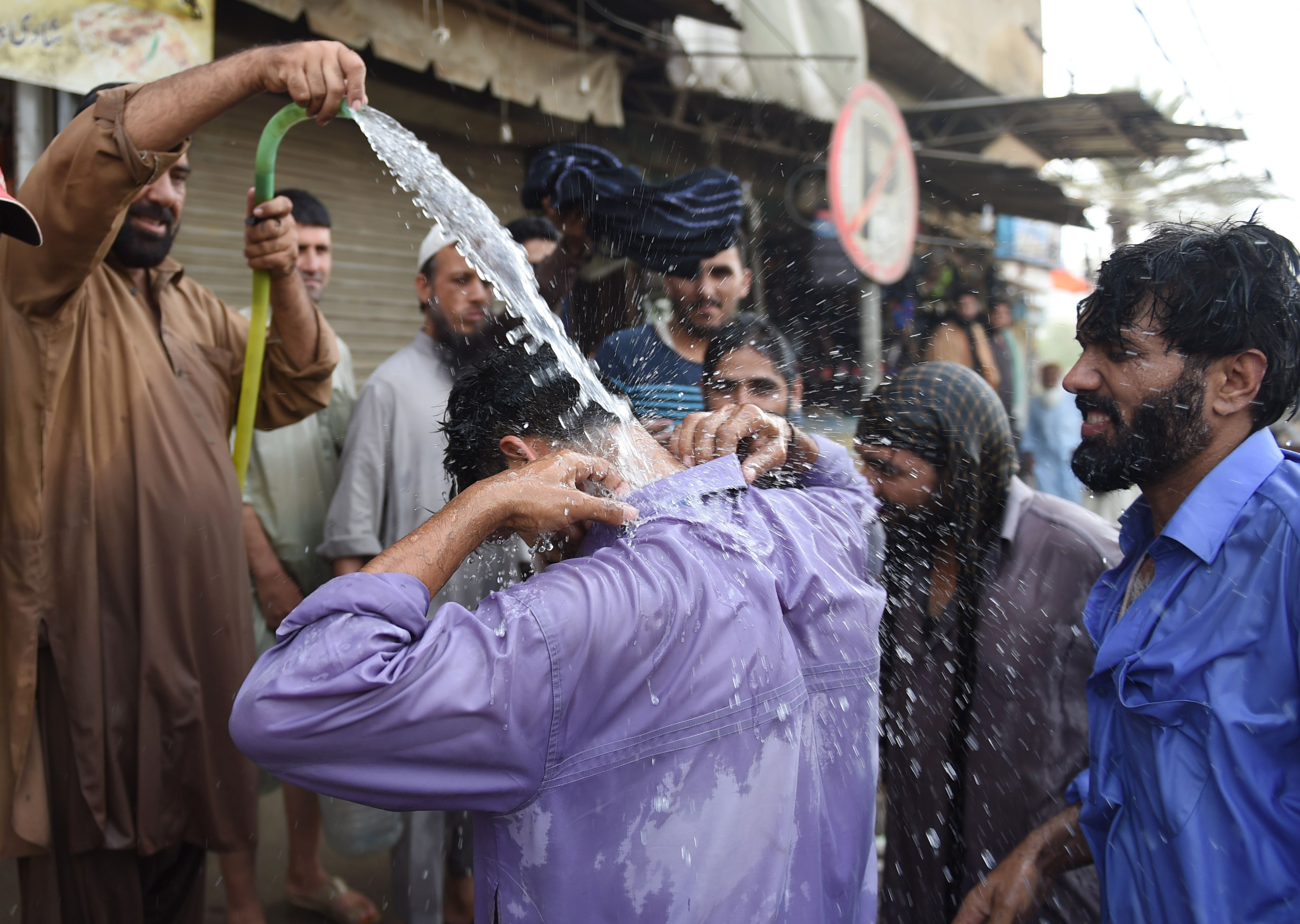 رجل يبلل جسمه بالكامل بسبب الحر الشديد بباكستان