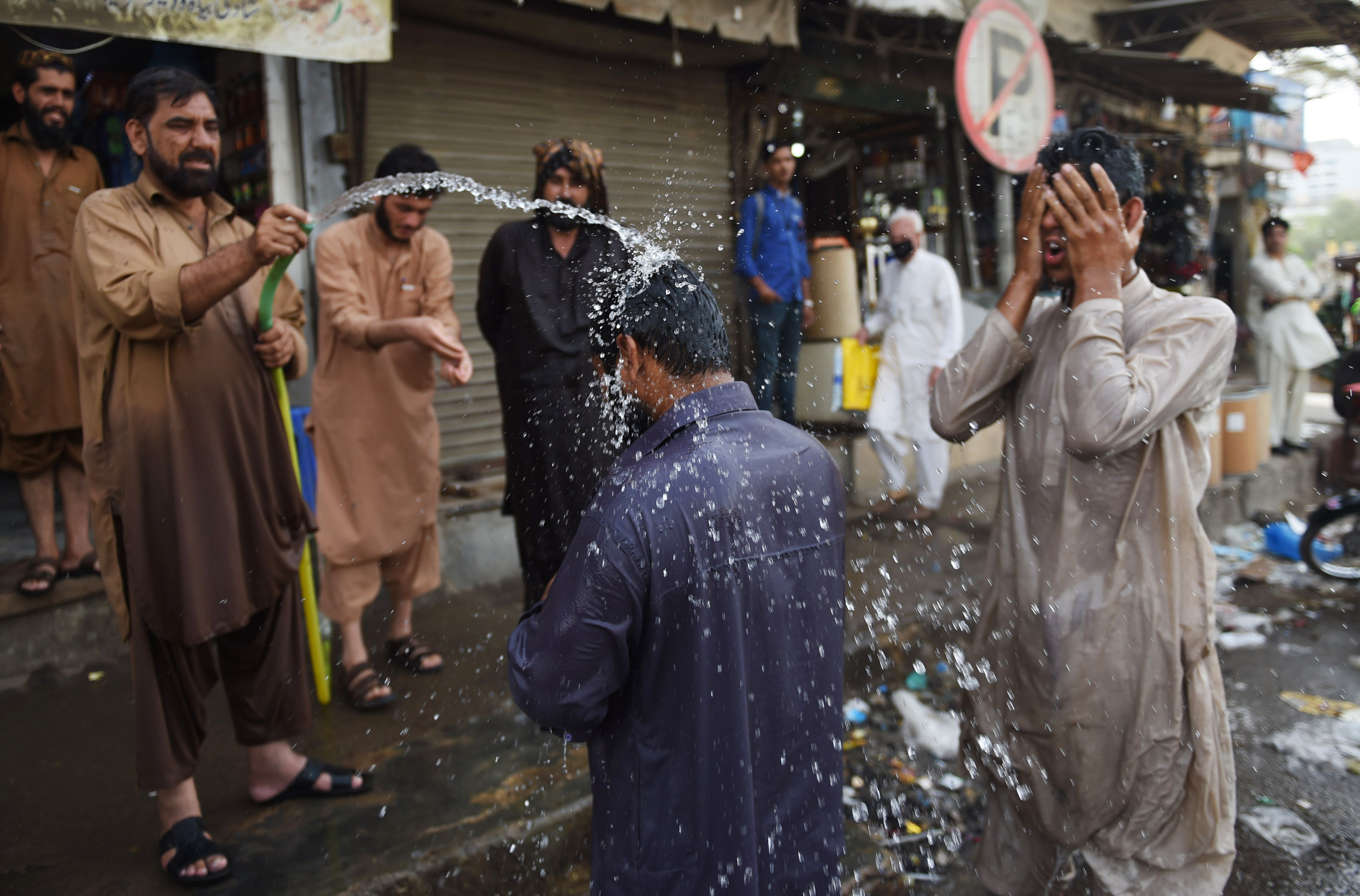رجل يرش مياه على المواطنين لتجنب موجة الحر الشديدة