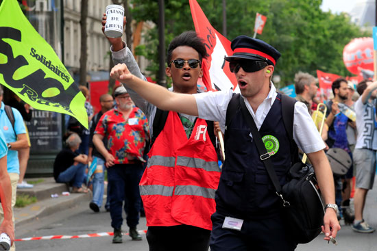 متظاهرون فرنسيون يحملون لافتات معارضة لماكرون 