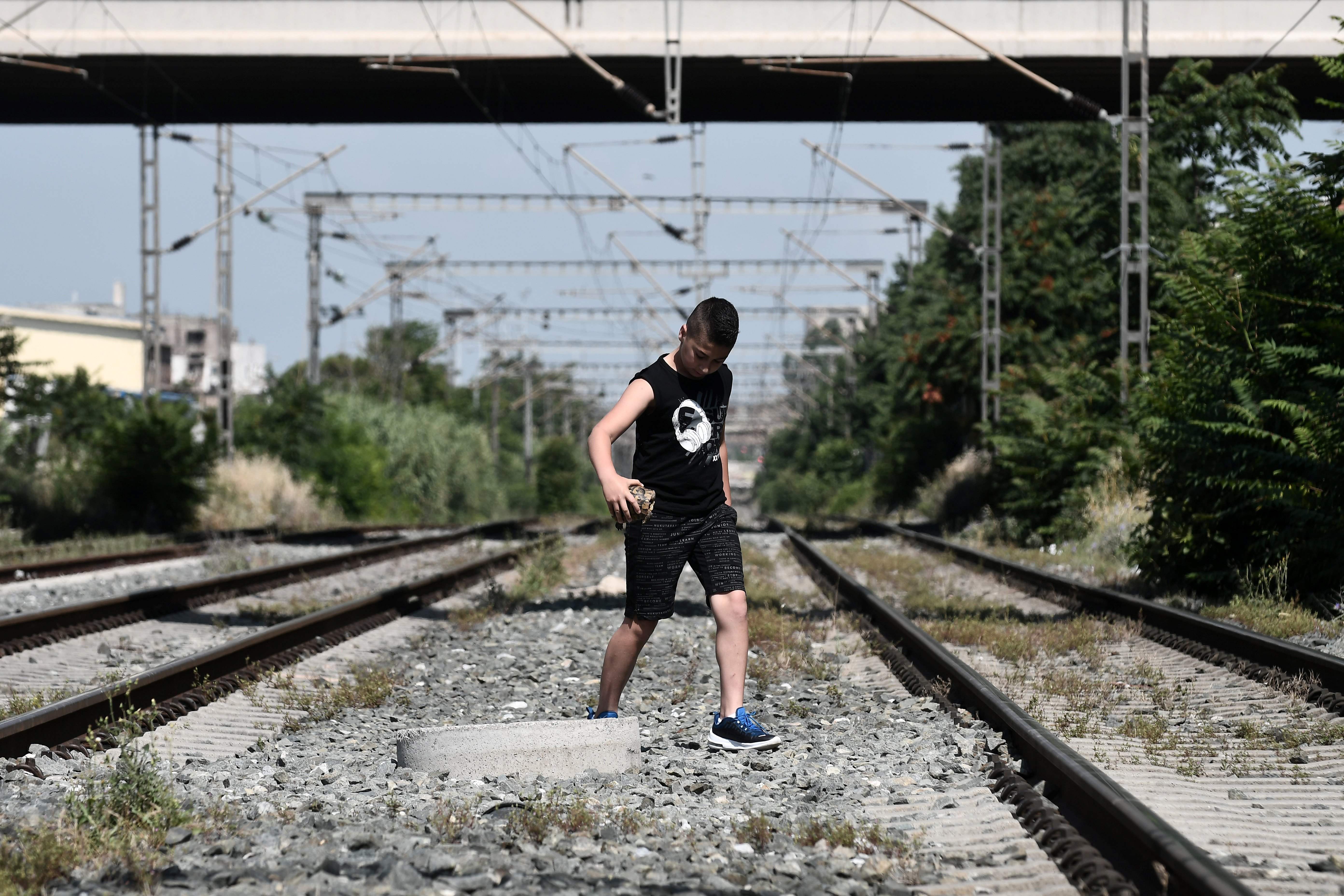 شاب يونانى يتوسط قضبان السكك الحديد خلال الاضراب