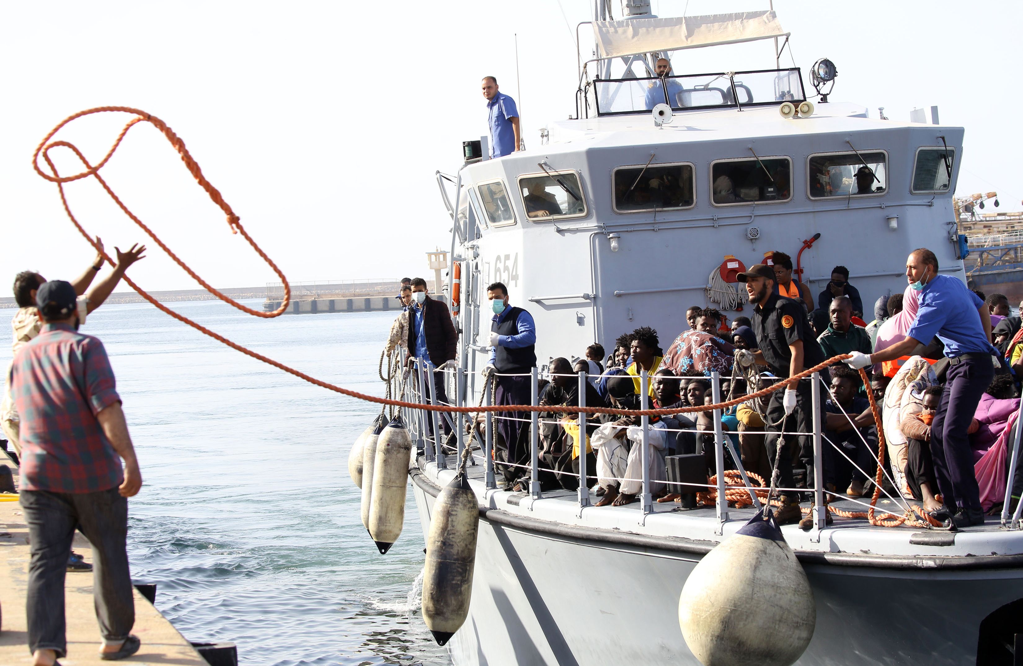 خفر السواحل الليبى ينقل المهاجرين عقب انقاذهم وسط المياه