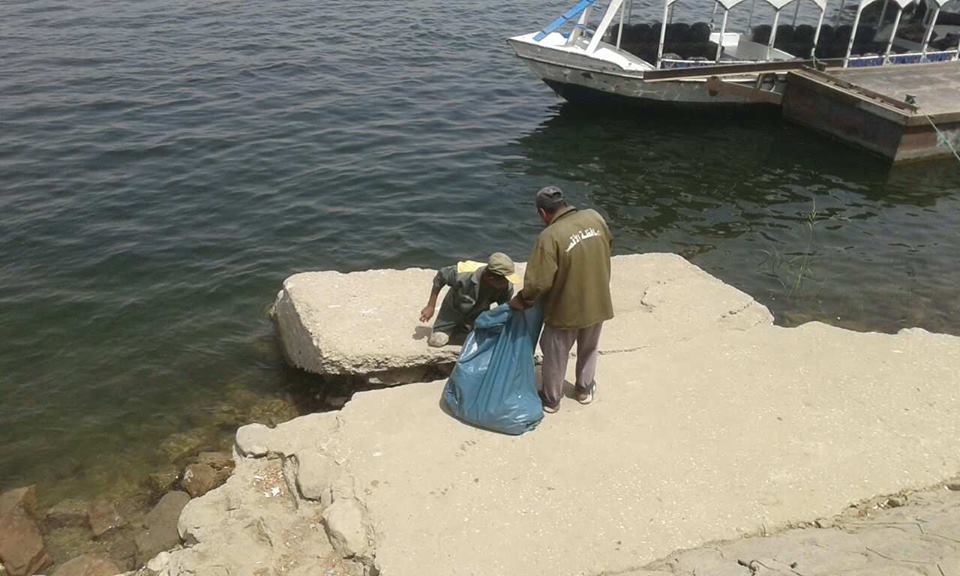    عمال المجلس خلال رفع القمامة والمخلفات من النيل