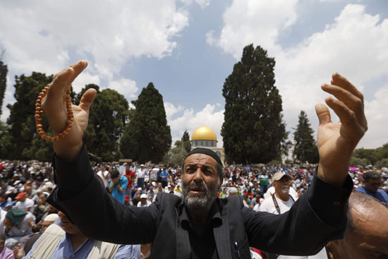 رجل فلسطينى يتوجه إلى الله بالدعاء من أمام المسجد الأقصى