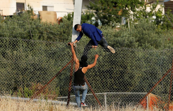 شبان فلسطينيين يتسلقون الحواجز الحديدية للعبور إلى القدس