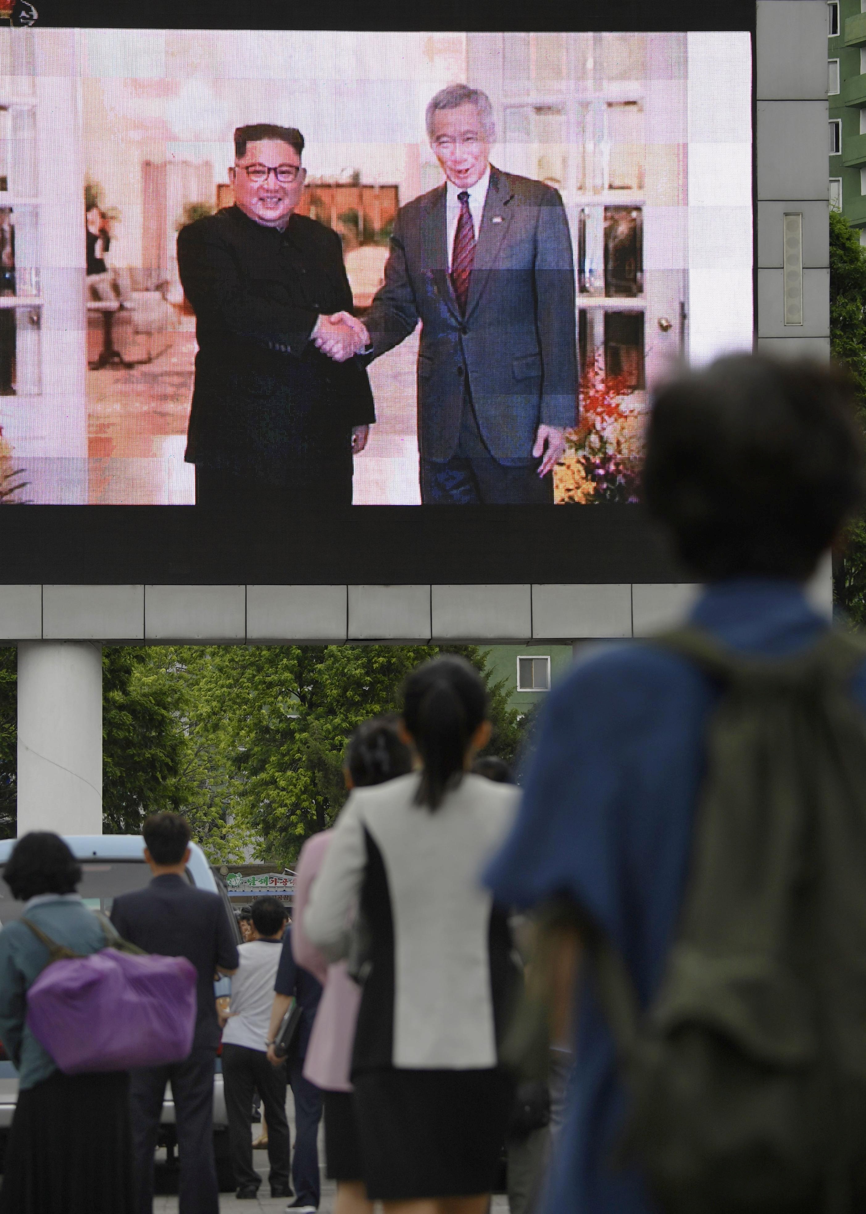 المواطنون يتابعون الشاشات أثناء لقاء زعيم كوريا الشمالية مع رئيس وزراء سنغافورة