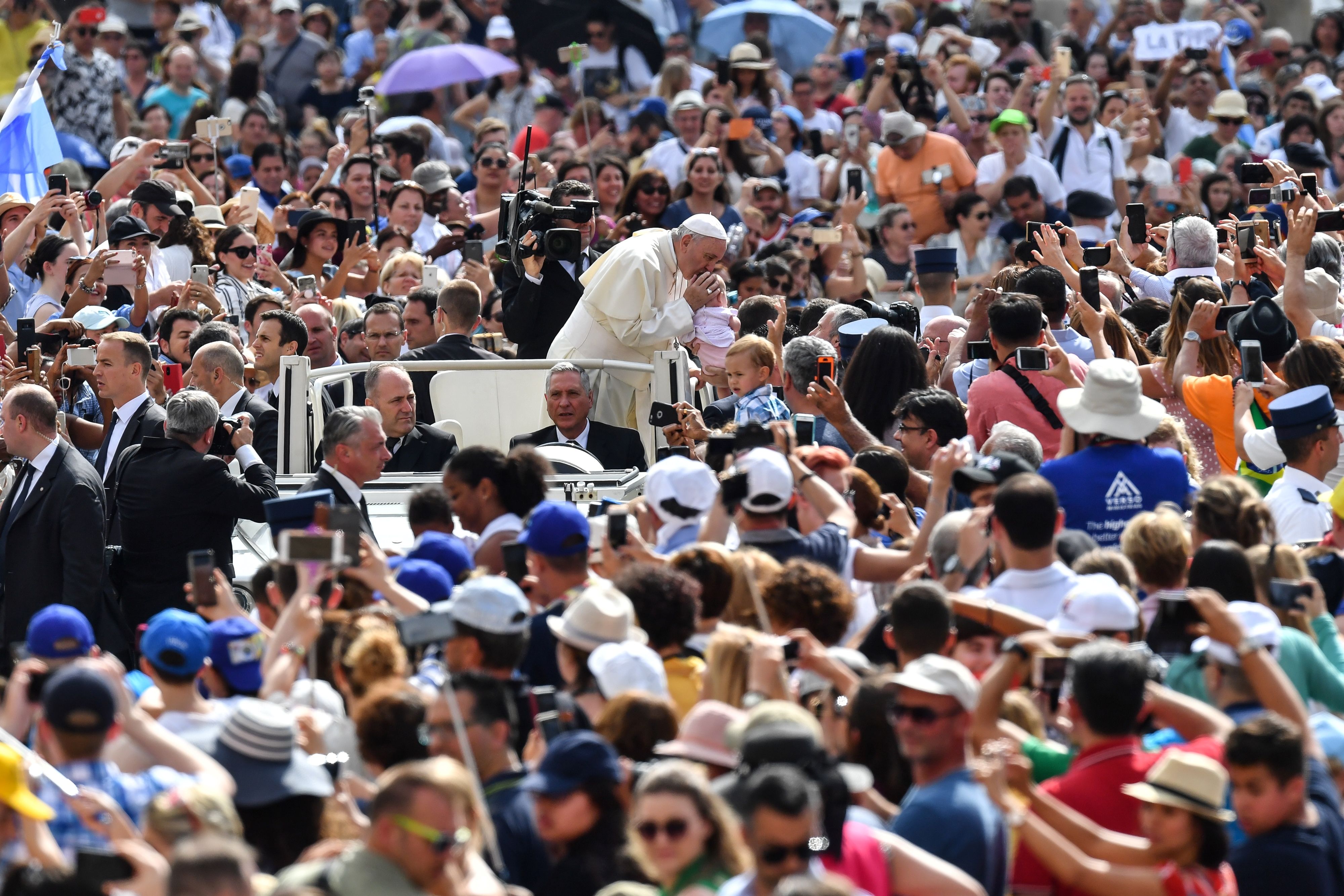 	البابا يقبل أحد الأطفال وسط مئات المواطنين الذين جاءوا لحضور لقاءه الأسبوعى