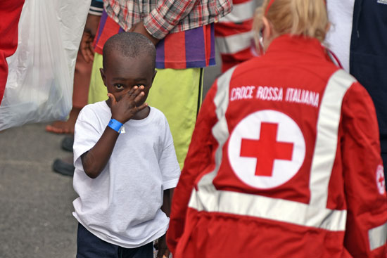 طفل بصحبة إحدى مسعفات الصليب الأحمر