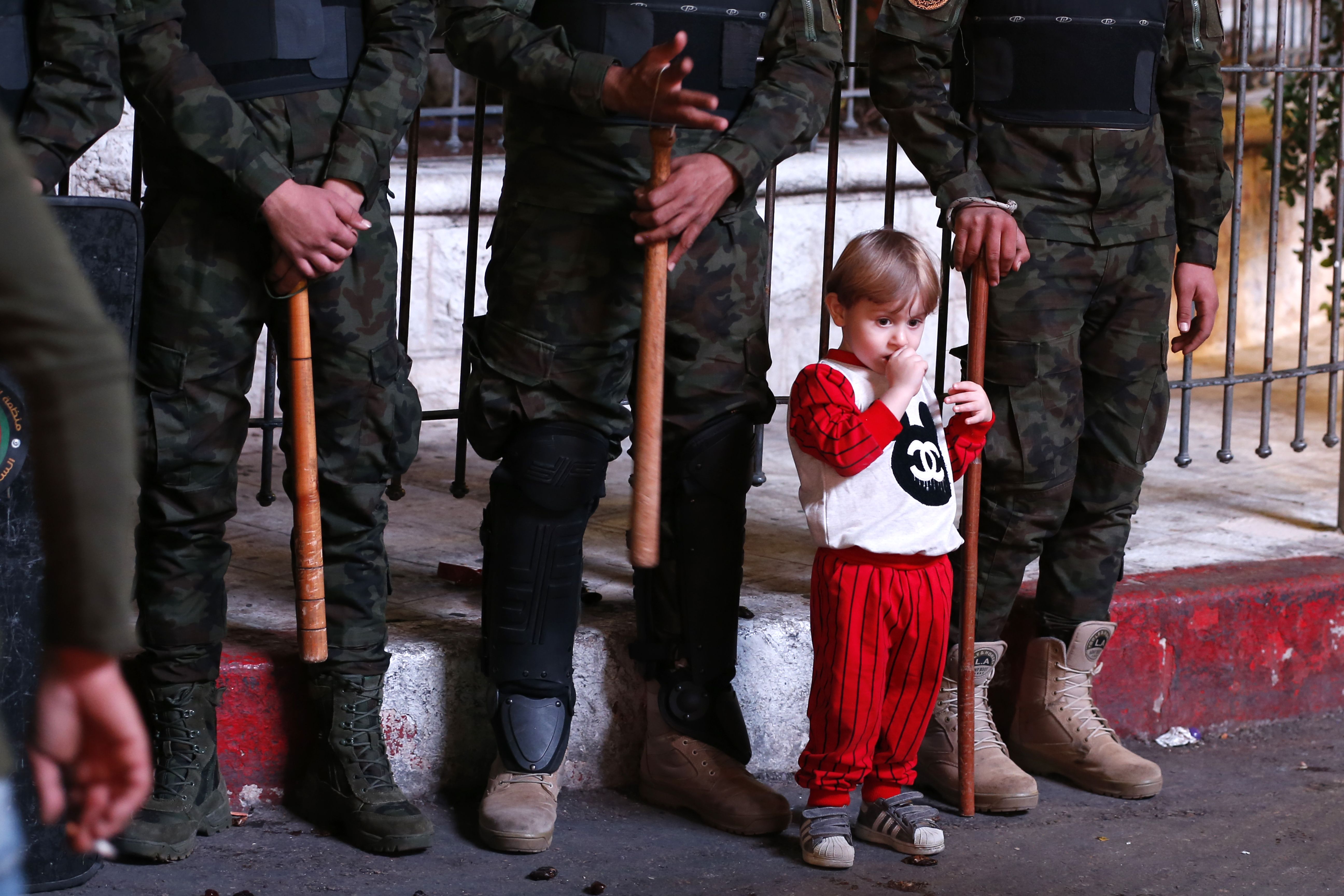 طفل فلسطينى يقف بين الجنود الفلسطينيين فى رام الله
