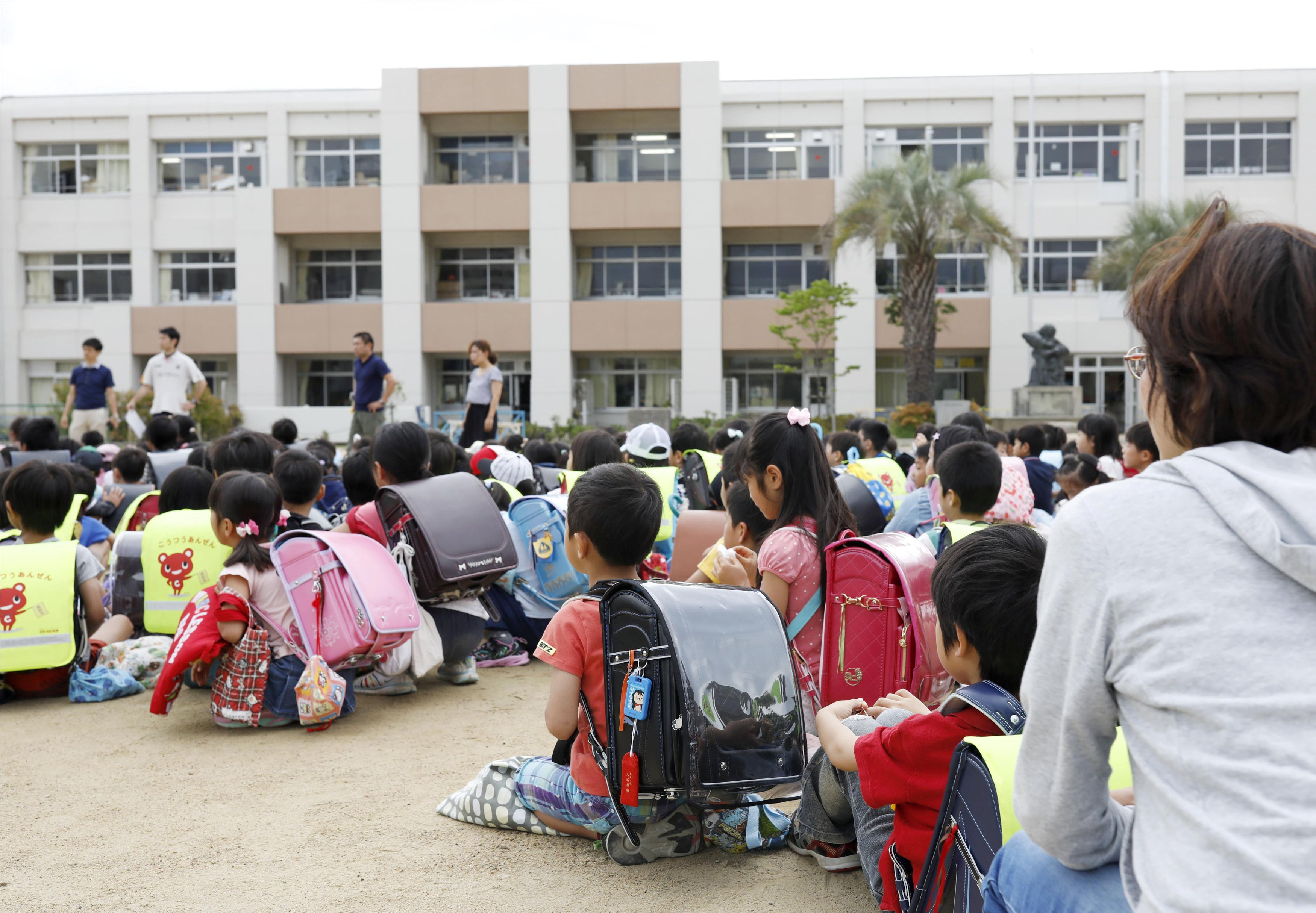 	أطفال يابانيين فى ملعب مدرستهم بعد إخلاء الفصول