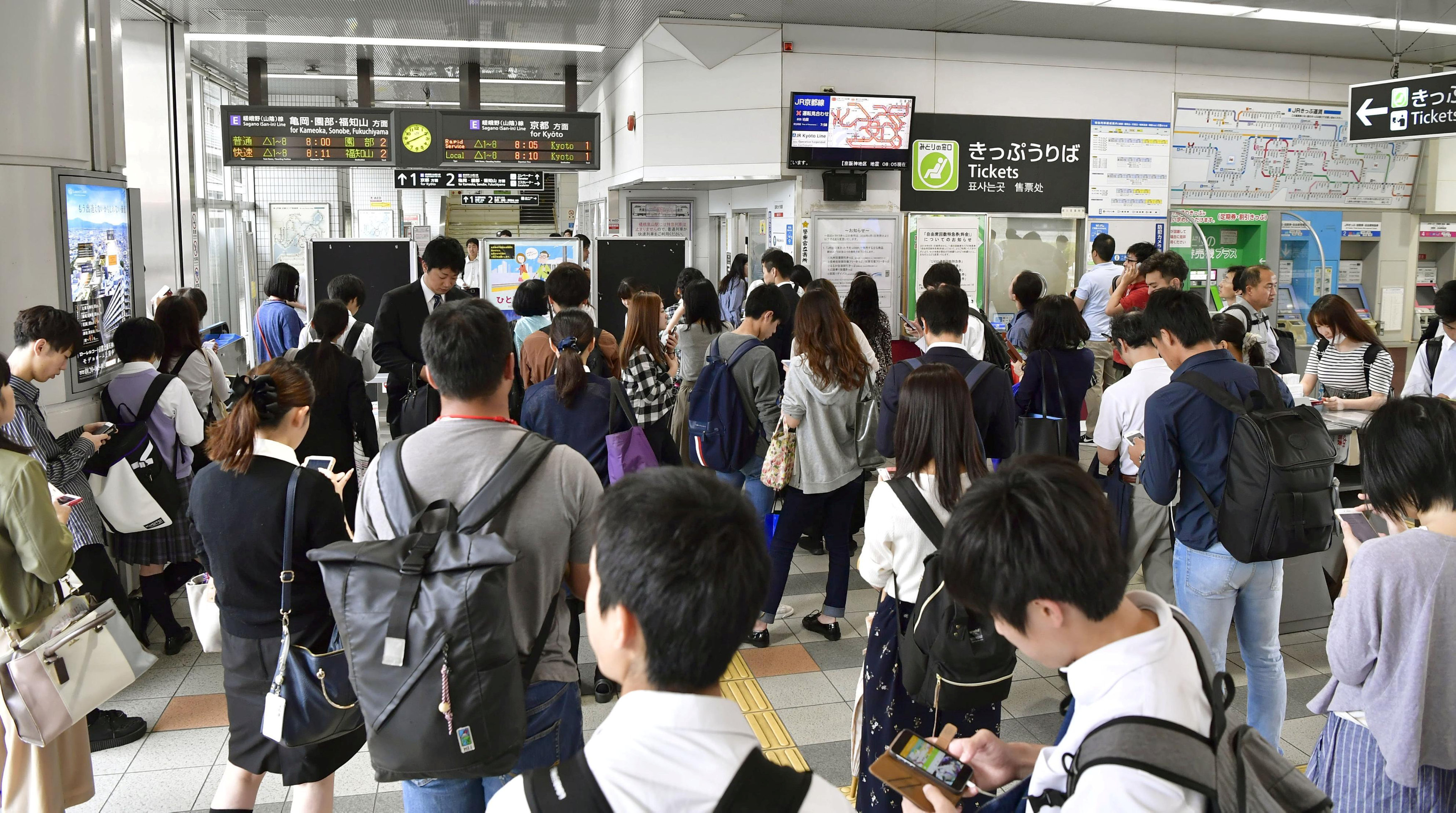 	مواطنين يابانيين بانتظار إعادة تشغيل القطارات