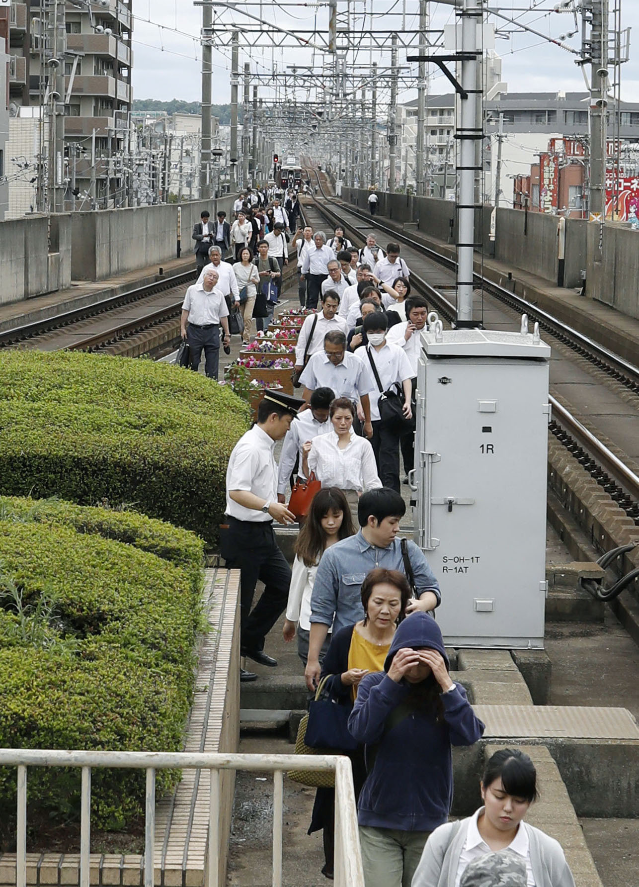 	مواطنين يترجلون على السكك الحديدية بعد إخلاء القطارات