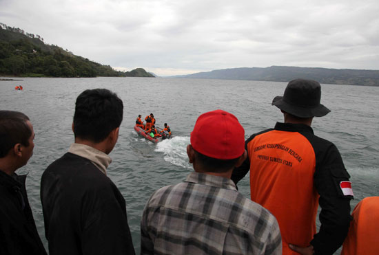 قارب يبحث عن ضحايا وسط متابعة من قبل أشخاص