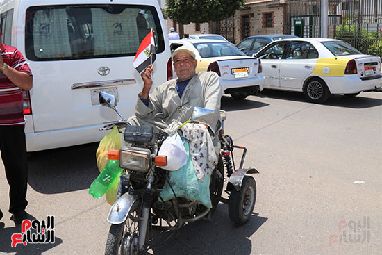 أحد ذوي الإحتياجات الخاصة يرفع علام مصر ابتهاجا بحلف الرئيس لليمين