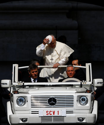 البابا يمسك بطاقيته التى تتطاير بفعل الهواء