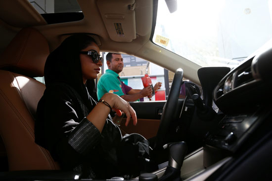 سيدة سعودية تنتظر ملئ سيارتها بالوقود