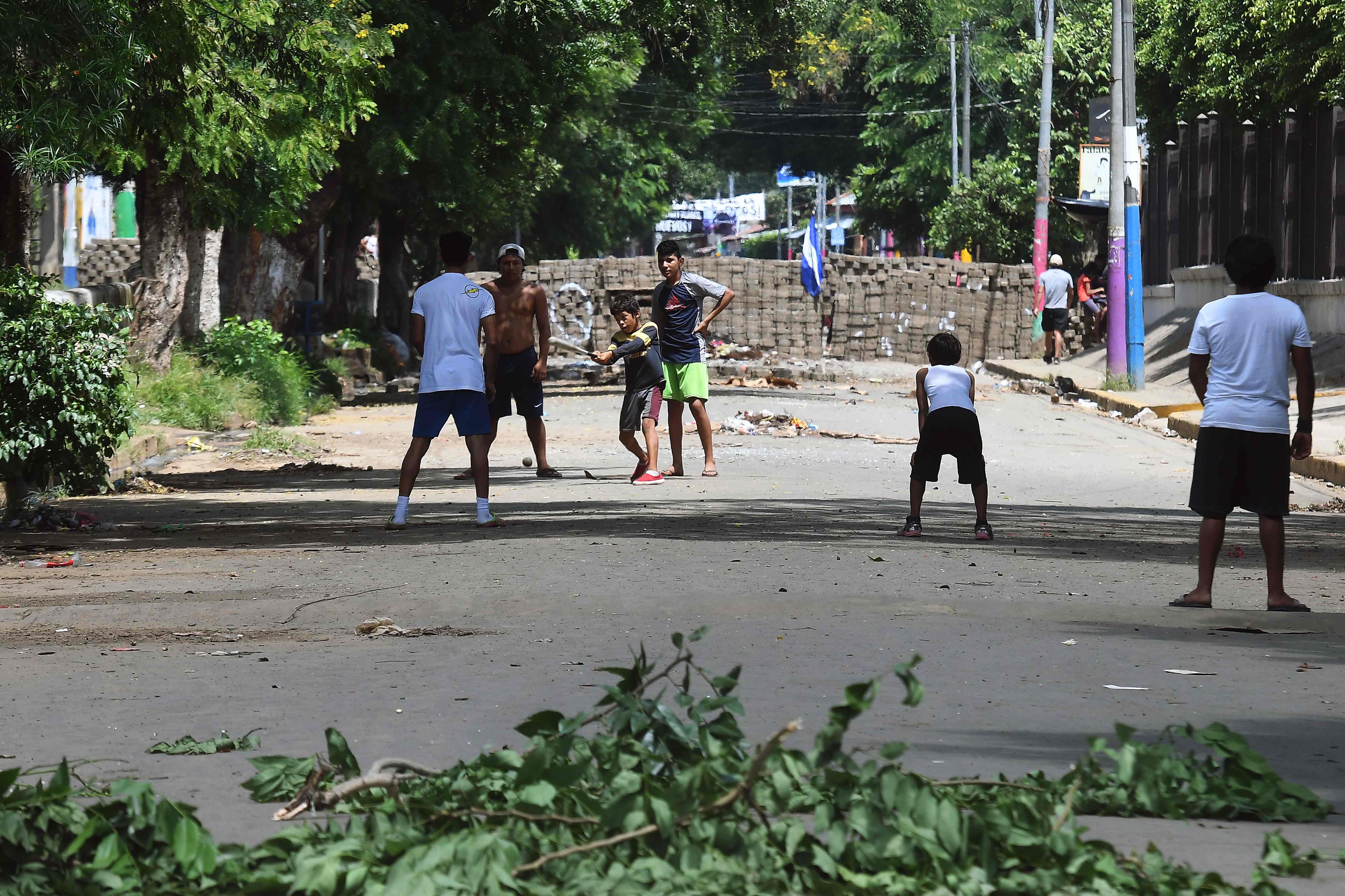 الشباب يلعبون الكرة عقب اغلاق طريق بالحجارة