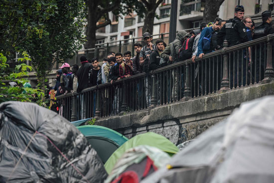 فرنسيون يتابعون إخلاء مخيم للمهاجرين فى باريس