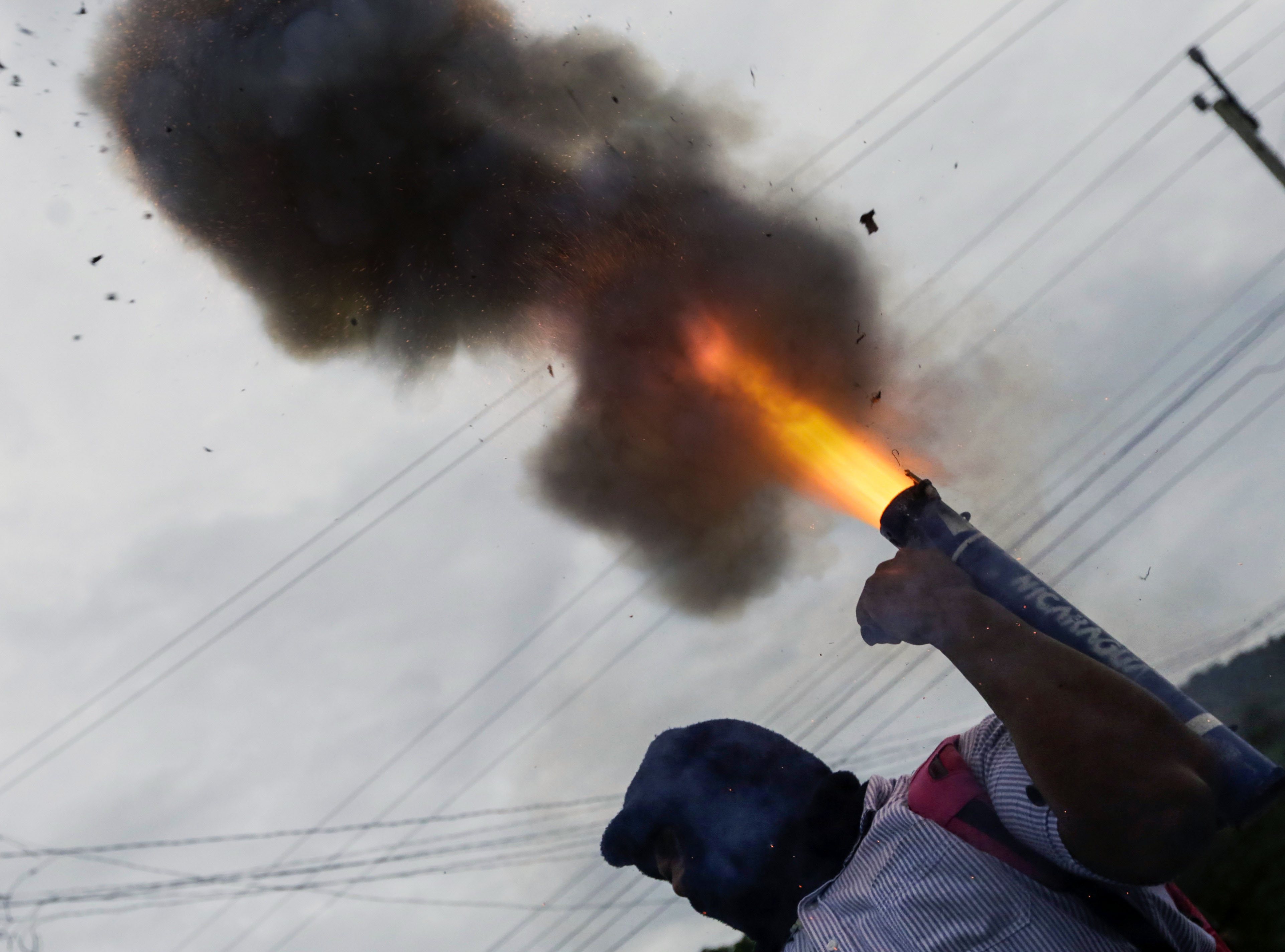 متظاهر يطلق قذيفة هاون خلال الاحتجاجات
