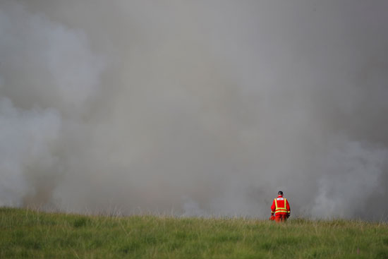 رجل إطفاء يقف أمام حريق فى وينتر هيل ببريطانيا