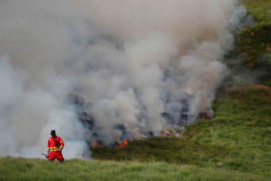 رجل إطفاء يبتعد عن مصدر اللهب فى بريطانيا