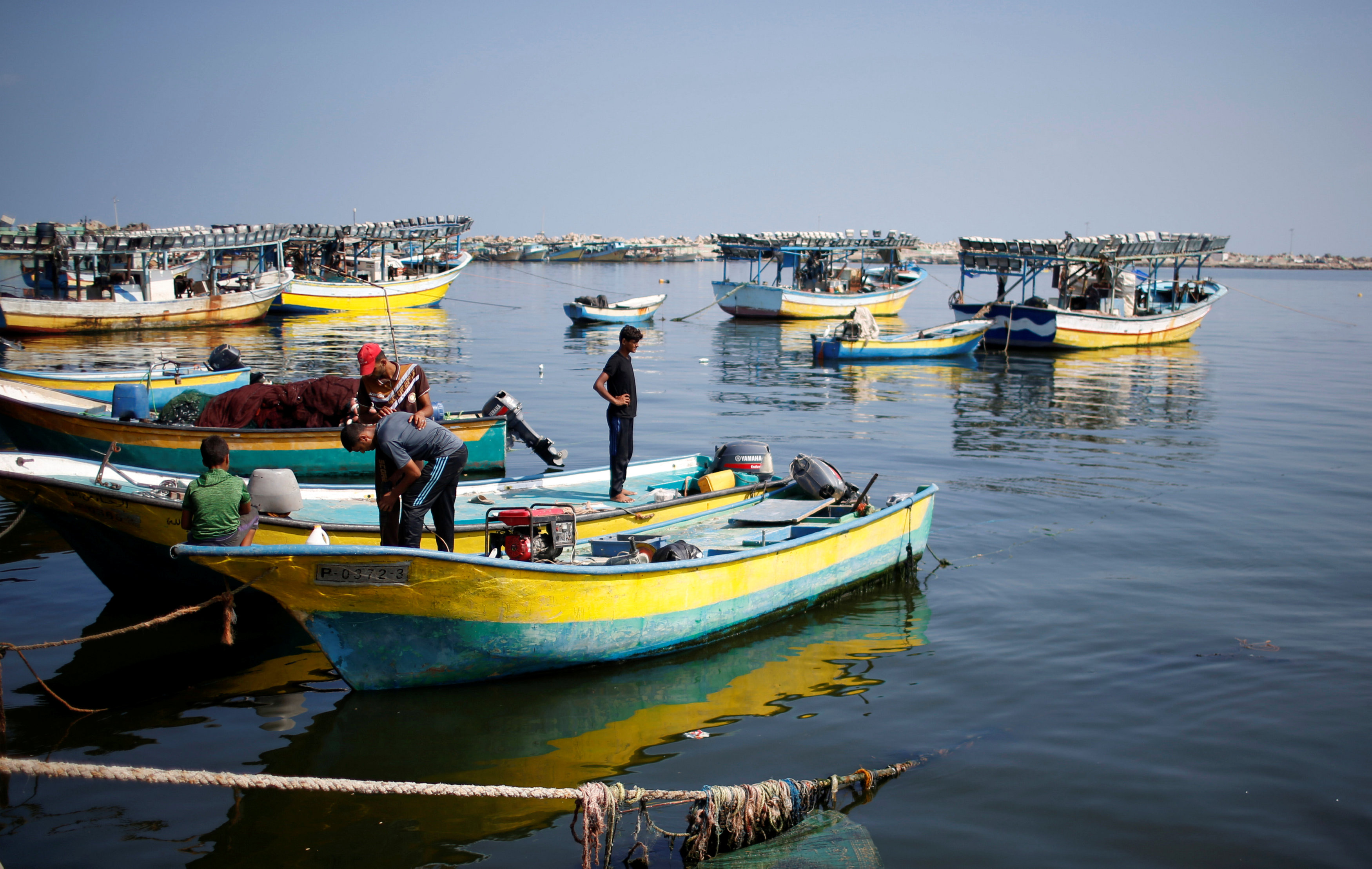 مواطن يحاول إصلاح شبكة الصيد الخاصة به بعد توقف القوارب بسبب نقص الوقود