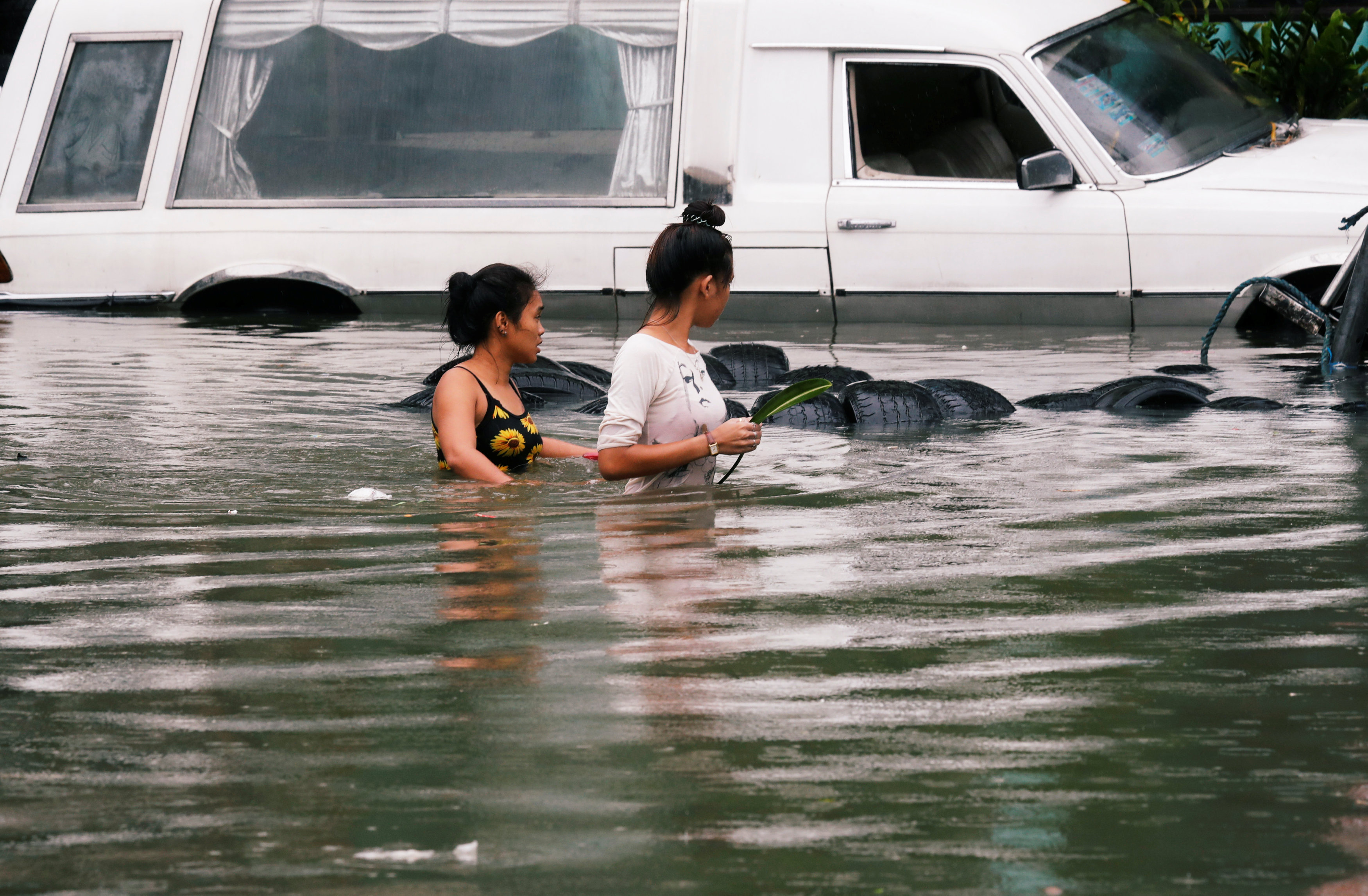 فتاتان تنظران بحسرة على سيارتهما التى تغطيها المياه