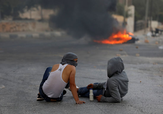 فلسطينيان خلال الاشتباكات