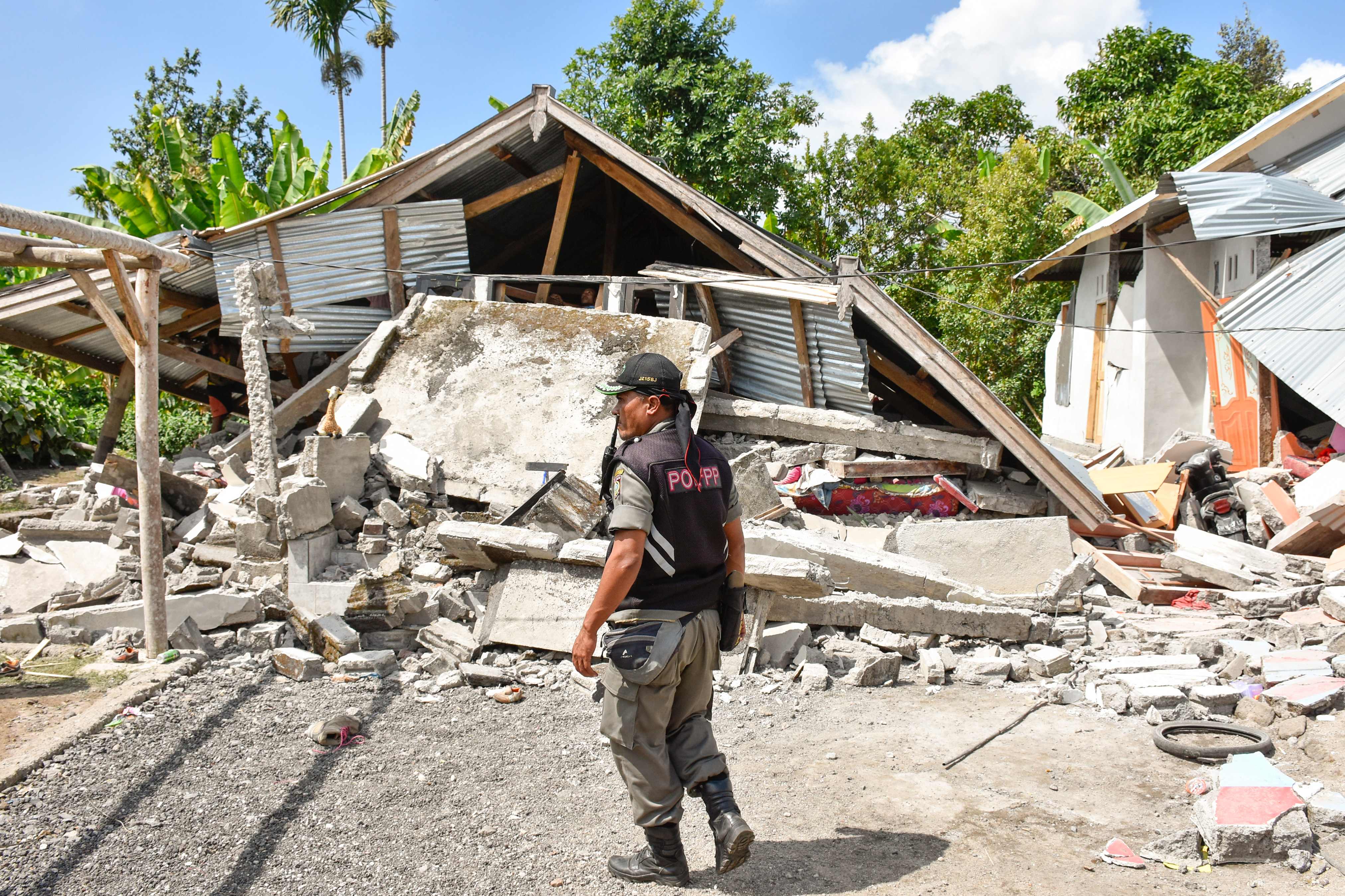 جندى يقف قرب منزله منهار بسبب الزلزال