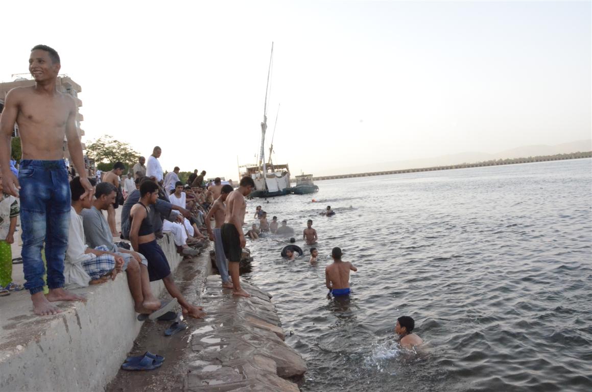     نهر النيل بمدن الأقصر يجذب الآلاف من الأهالي لمواجهة دراجات الحرارة المرتفعة
