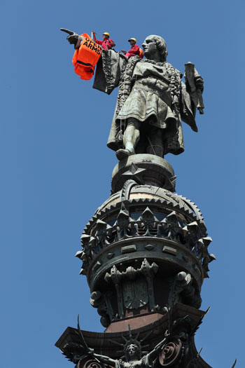 نشطاء "أوبن أرمز" يقفون فوق تمثال كريستوفر كولومبوس
