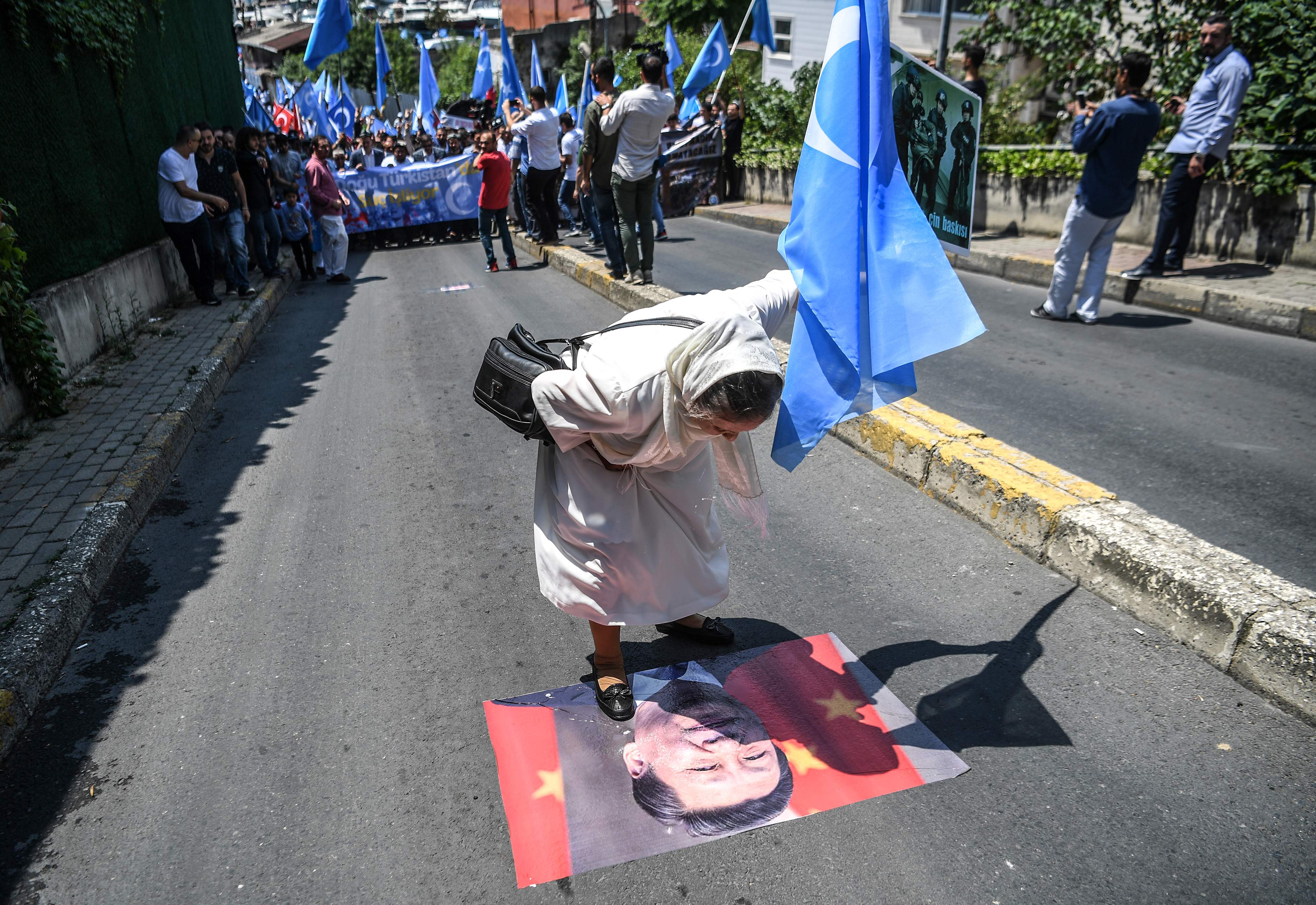 أحد المتظاهرين يضع قدمه على صورة الرئيس الصينى