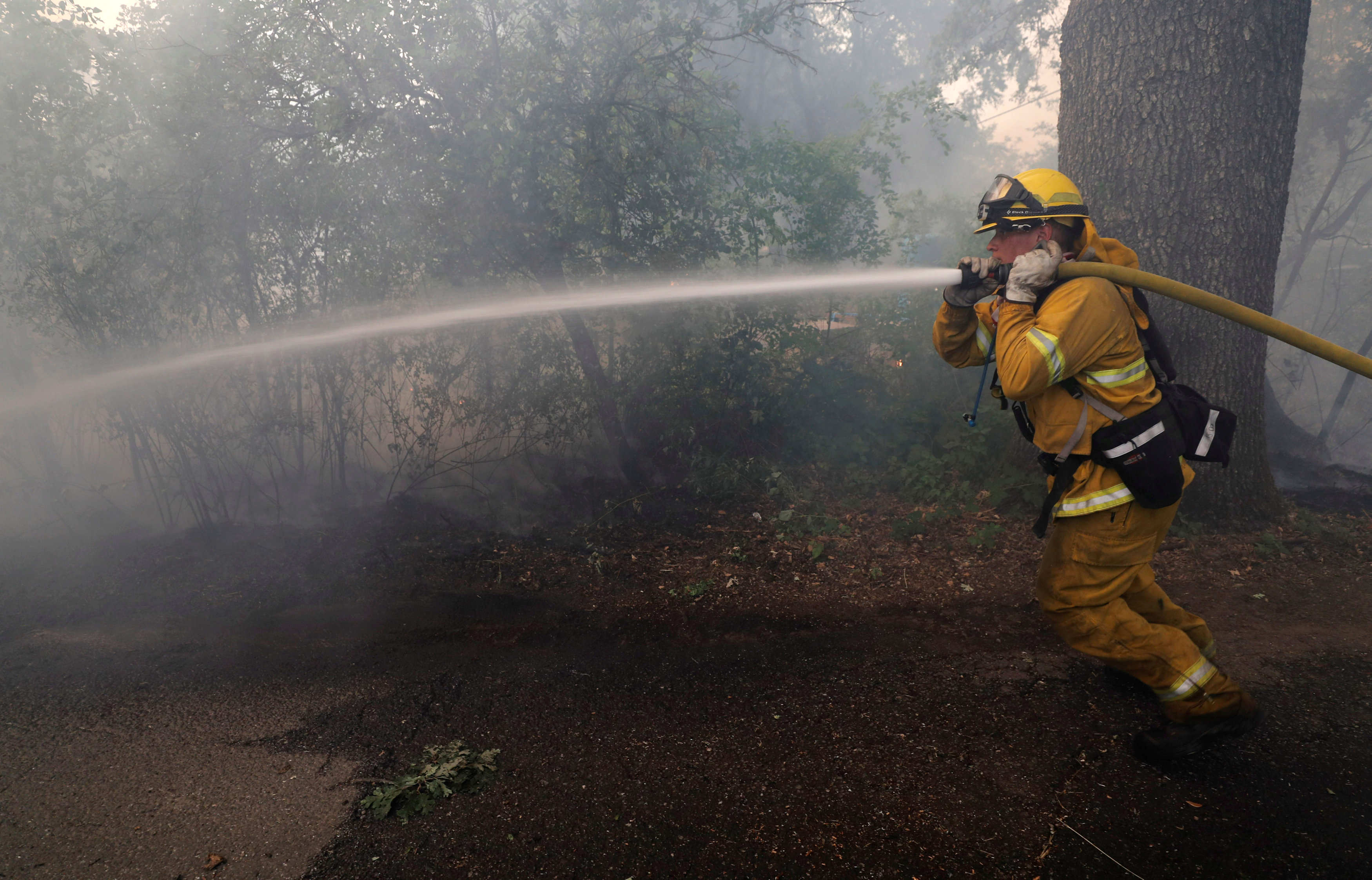 أحد رجال الإطفاء يحاول السيطرة على الحرائق
