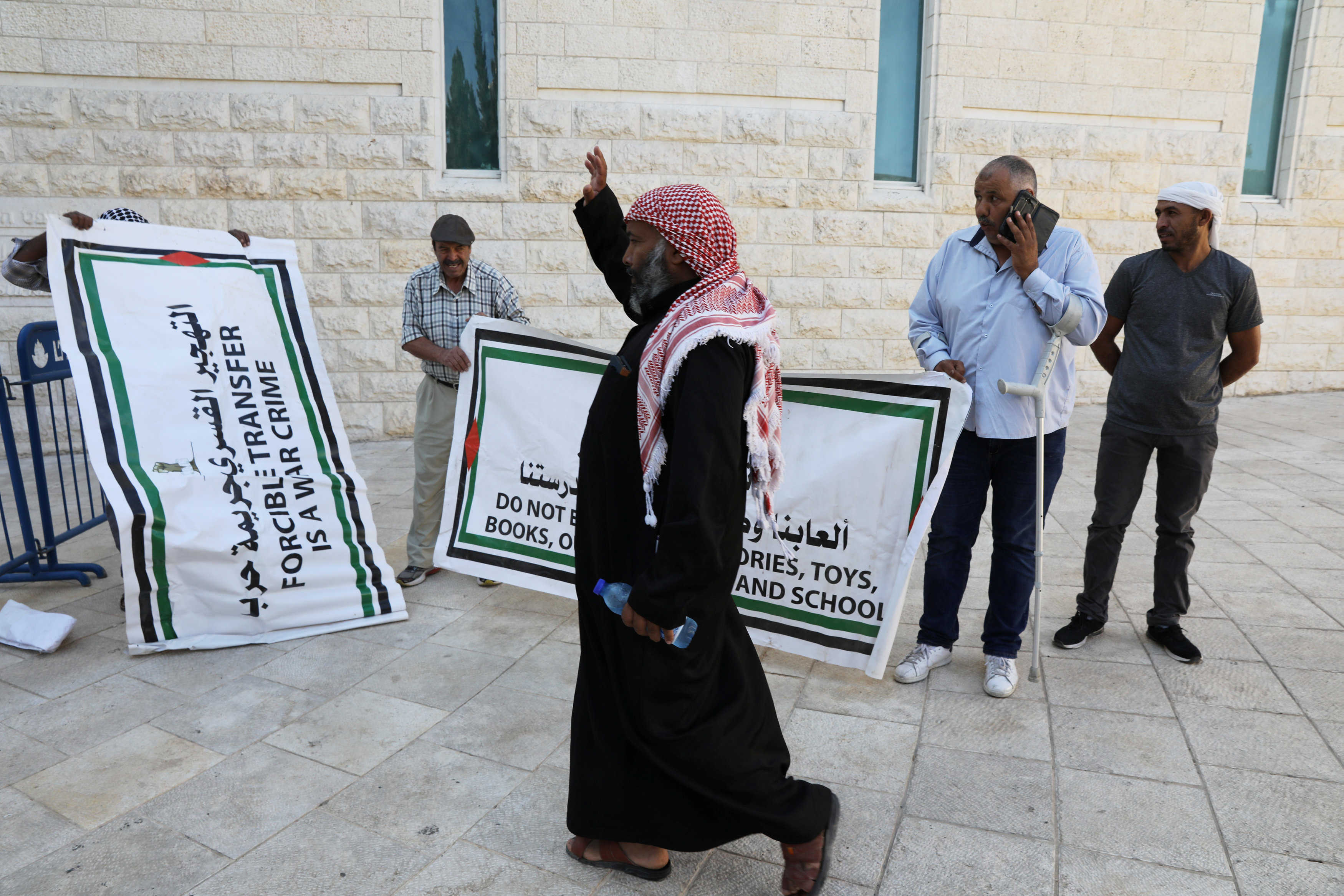 لافتات يحملها فلسطينيون لإدانة الانتهاكات الإسرائيلية