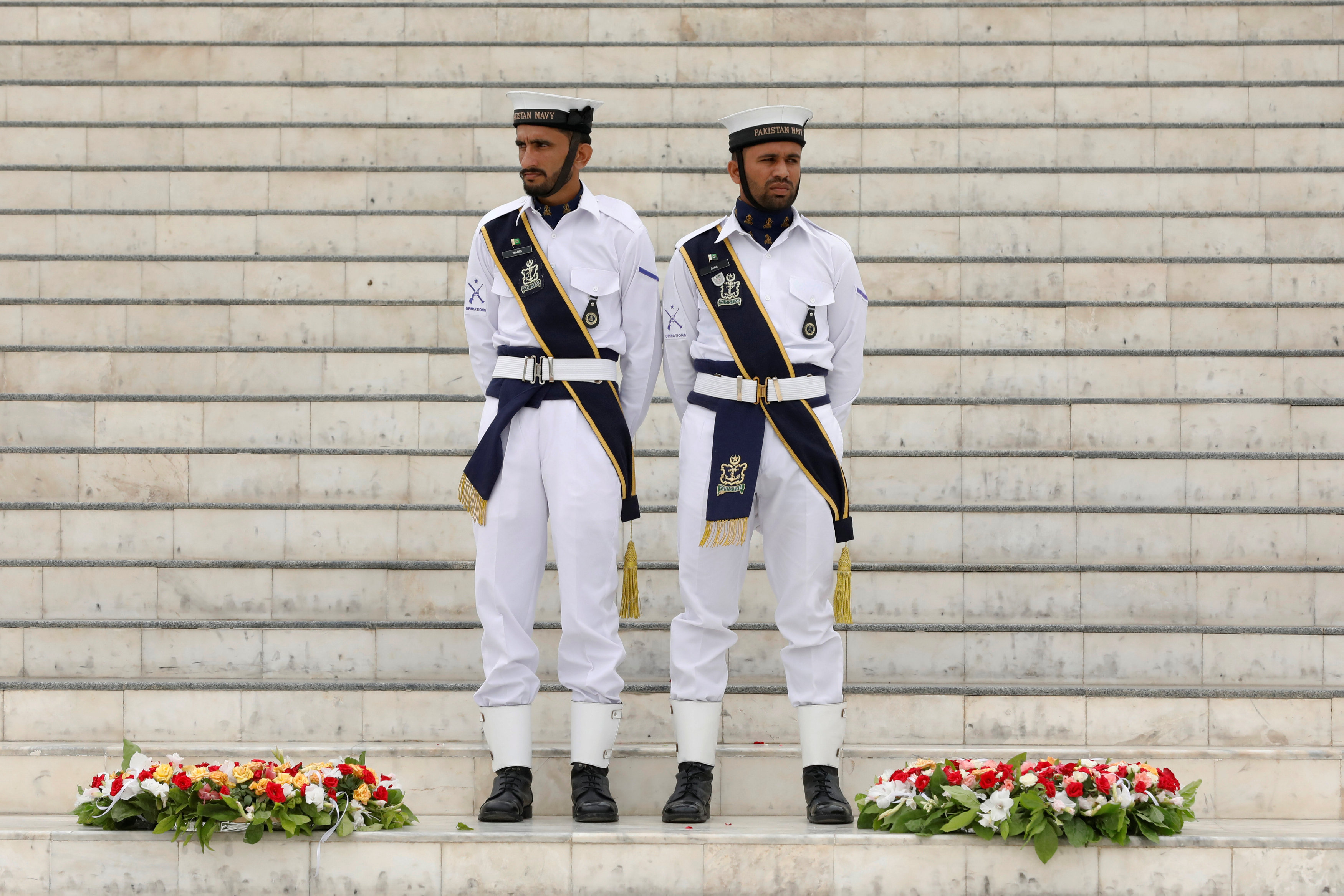 	يقف أفراد القوة البحرية الباكستانية بجانب أكاليل الزهور خلال احتفال عيد الاستقلال الـ71 