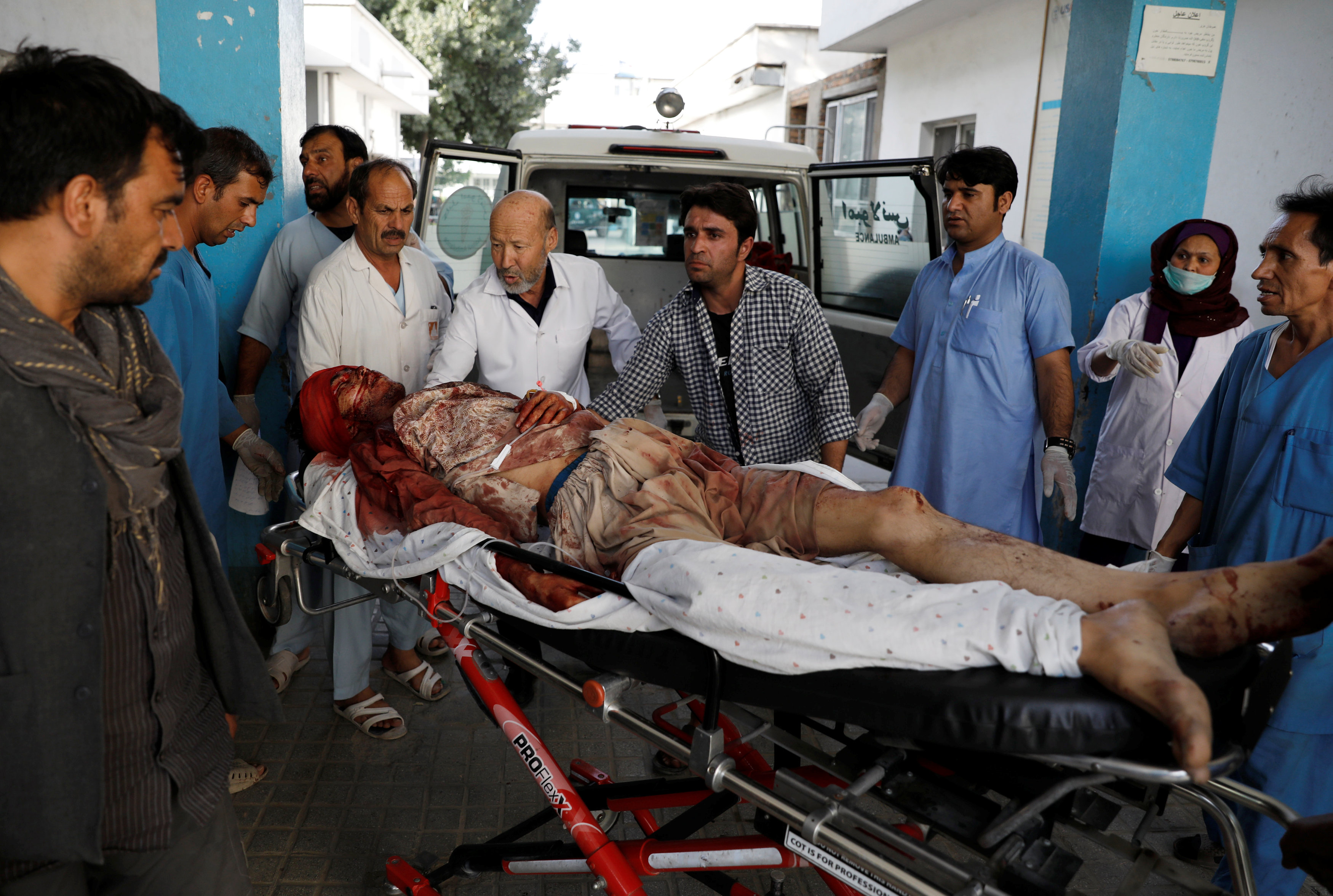 رجال يحملون جرحى في مستشفى بعد انفجار في كابول