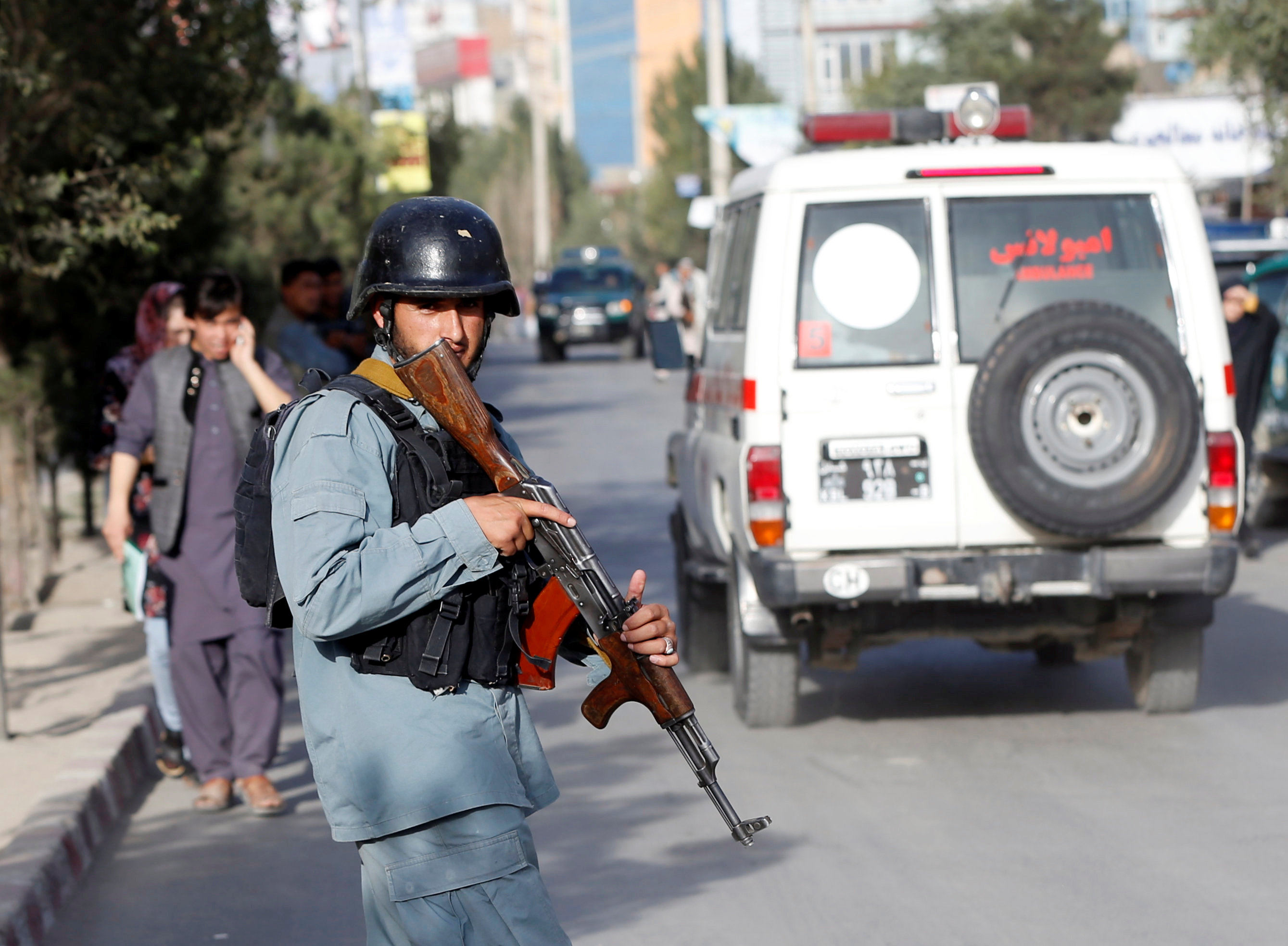 شرطي أفغاني يراقب الساعات قرب موقع التفجير 