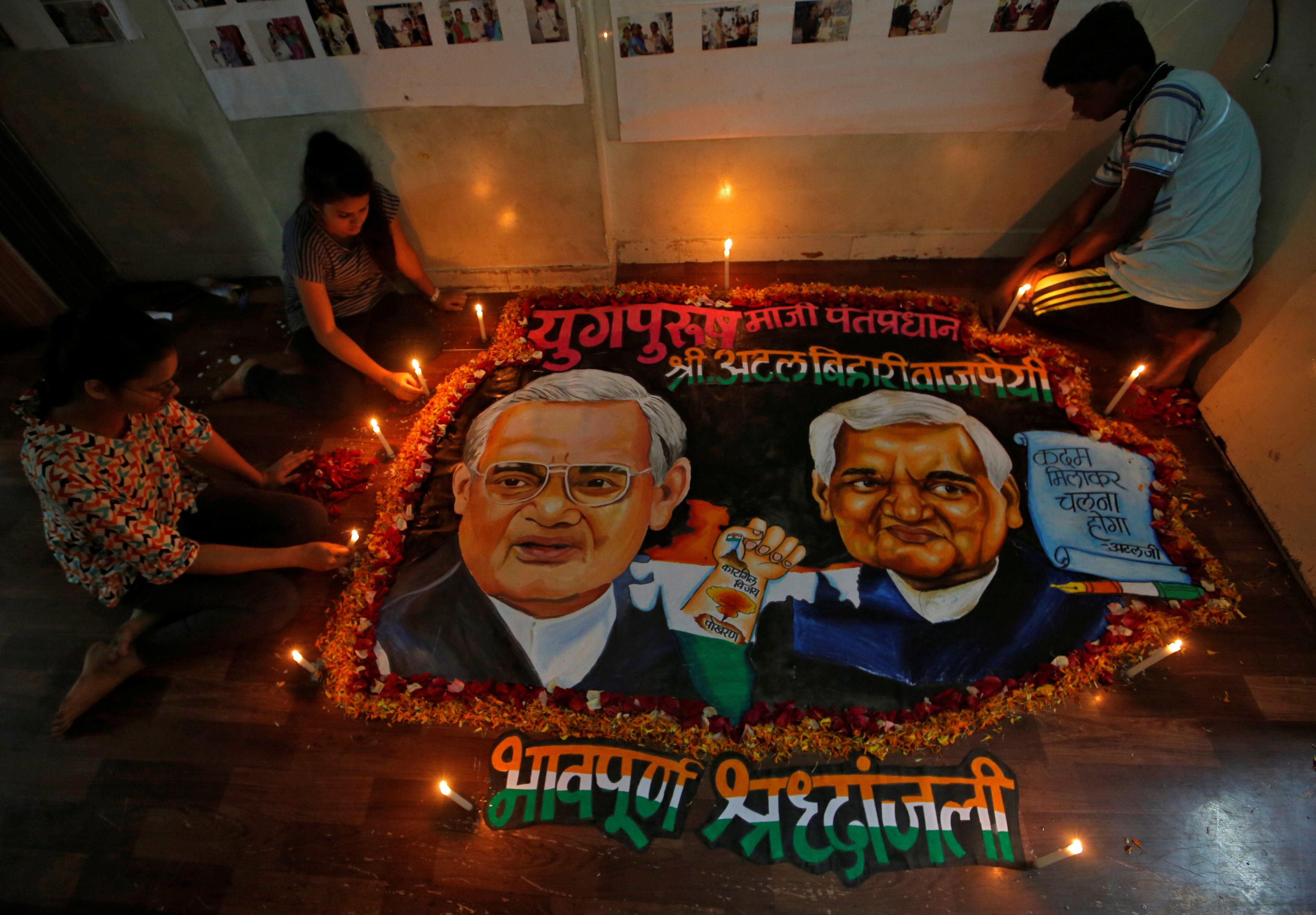 يضع الطلاب الشموع حول لوحة تضم رئيس الوزراء الهندي السابق  لتكريمه
