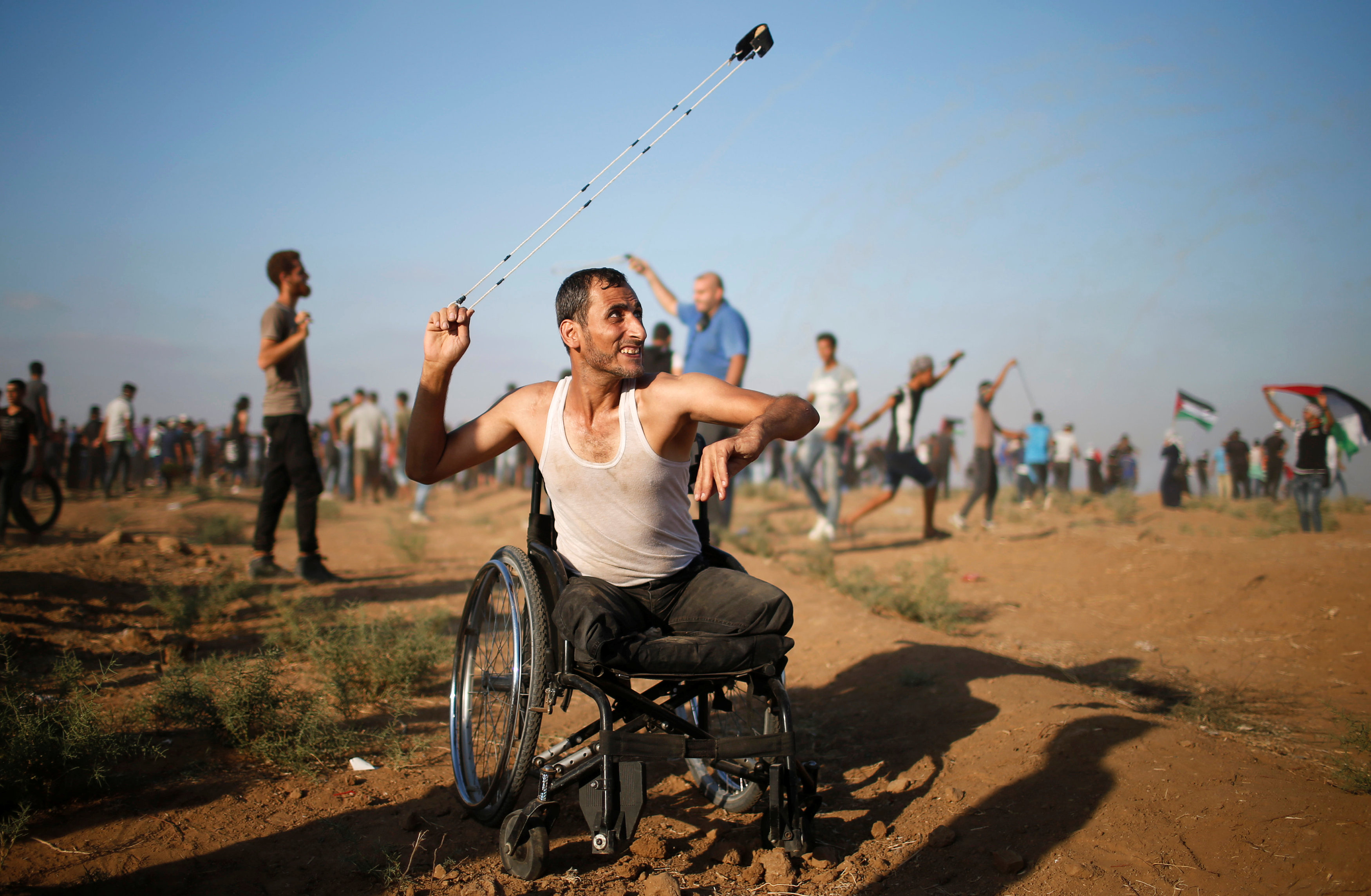 معاق فلسطينى يقذف قوات الاحتلال بالحجارة
