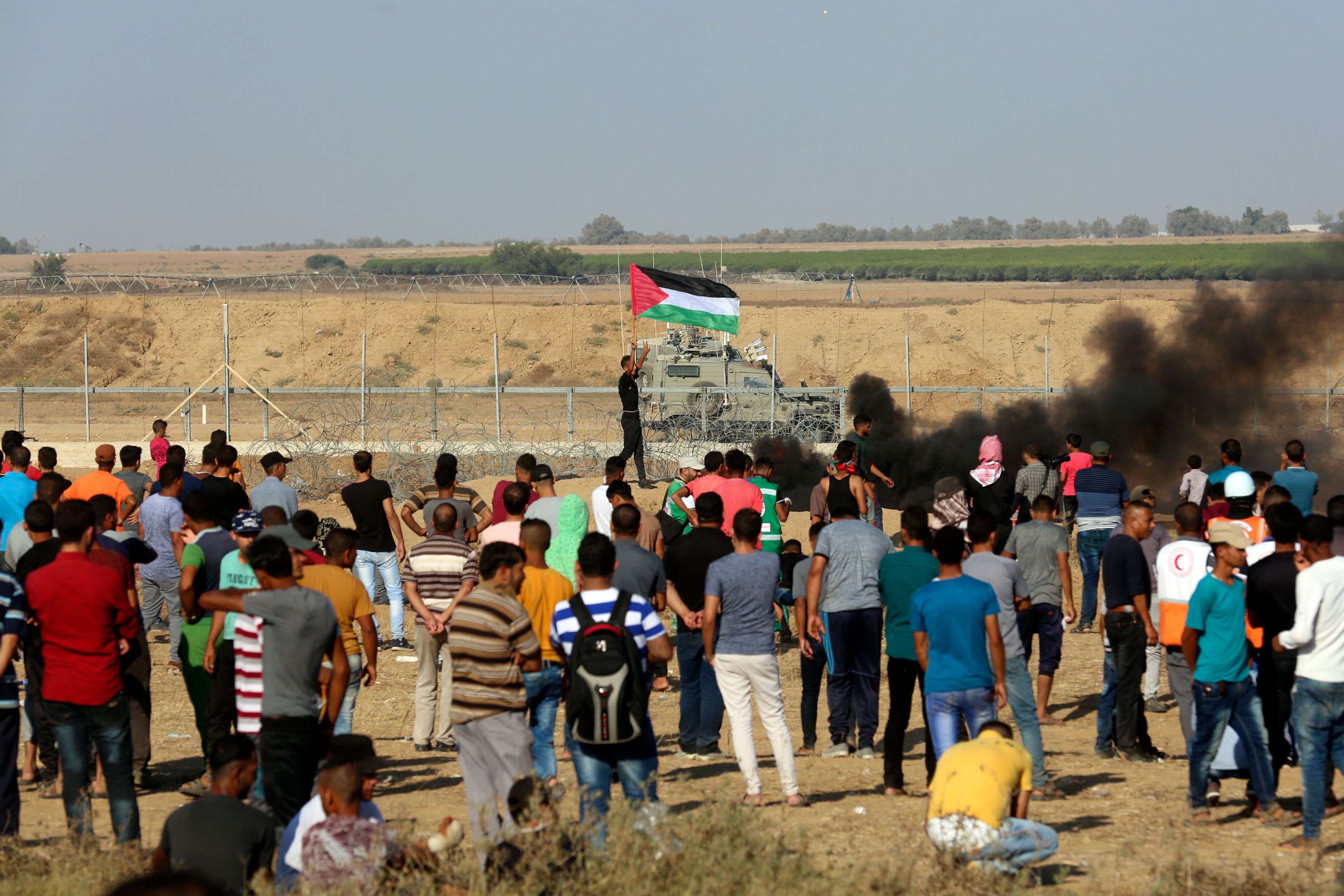 شاب يرفع علم فلسطين فى وجة قوات الاحتلال