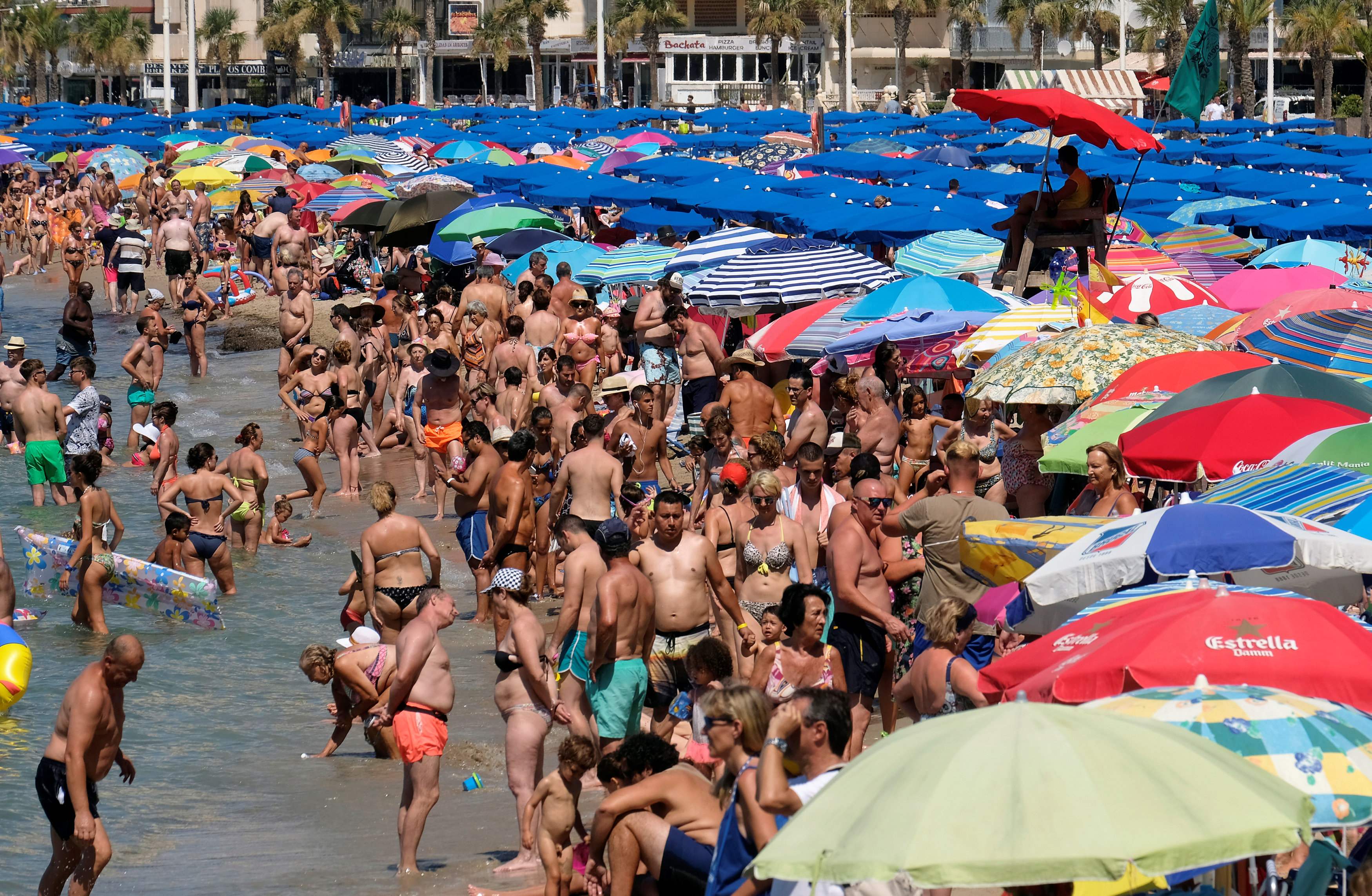 سكان فى إسبانيا يهربون إلى الشواطئ