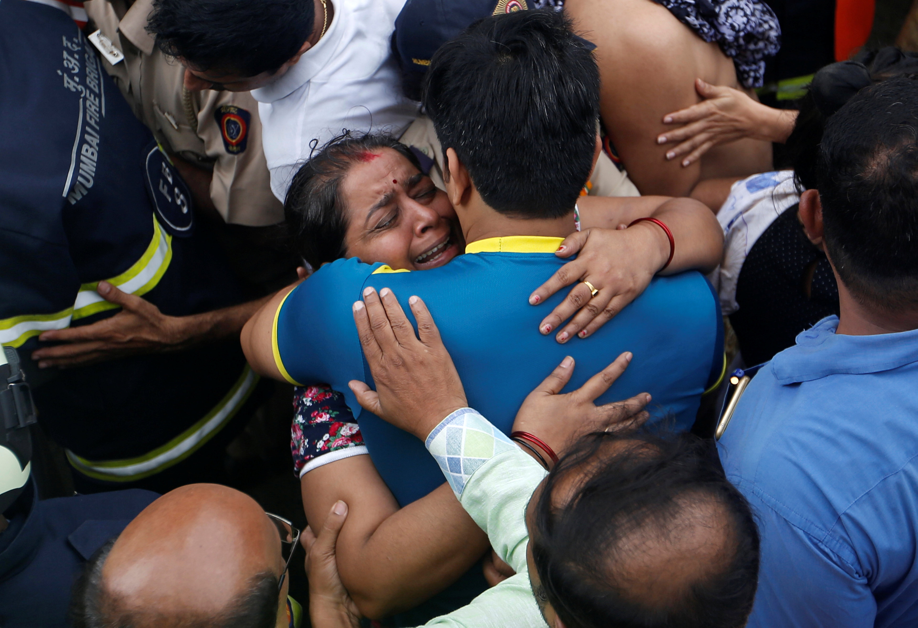 مواطنة تحتضن أحد أقاربها بعد إنقاذه من الحريق