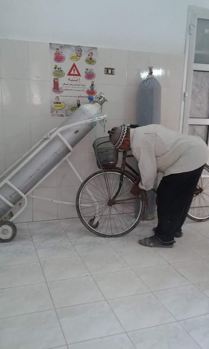  العامل ينفخ الدراجة الهوائية من أنبوبة الأكسجين بالمستشفى