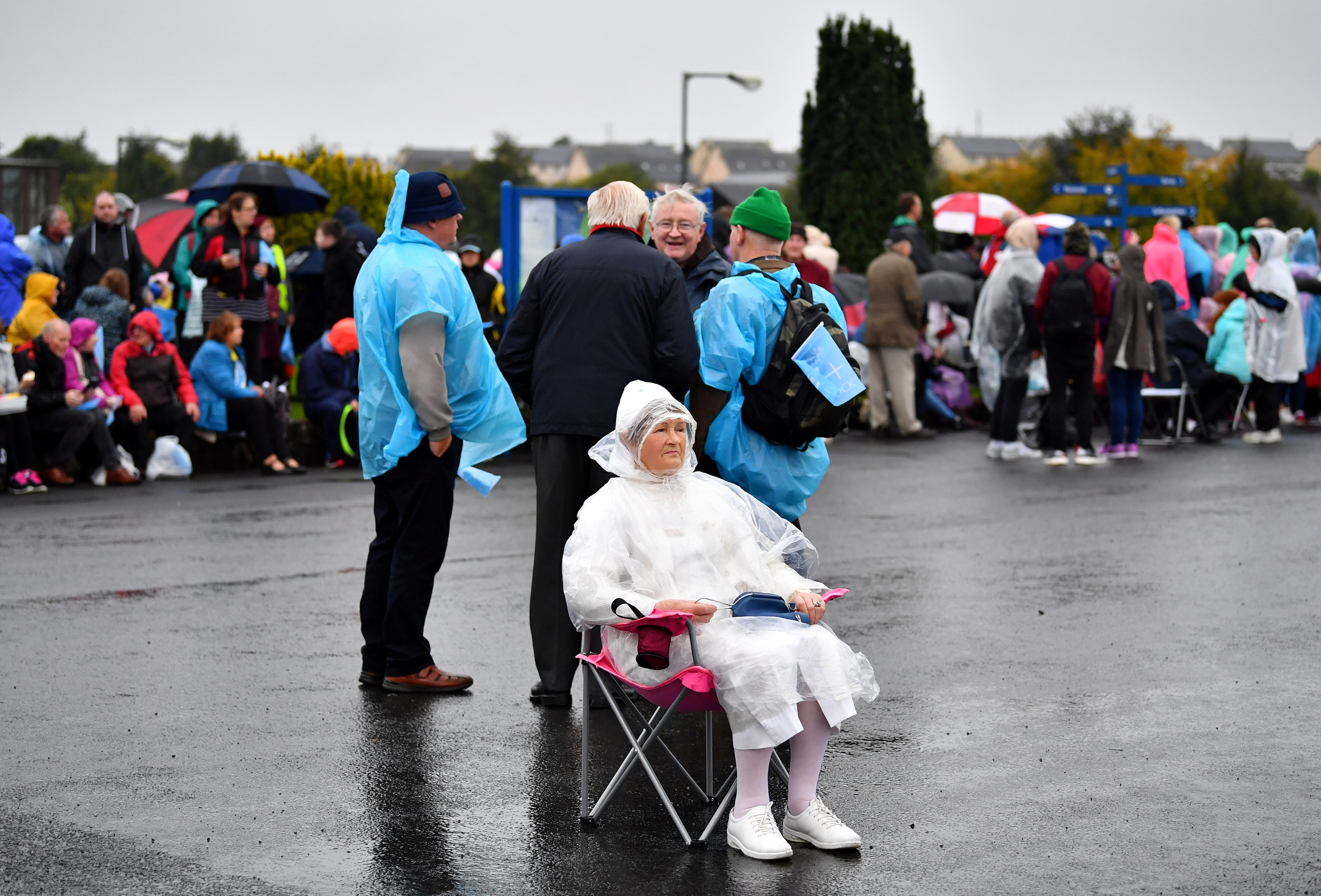 	سيدة مسنة فى انتظار البابا تحت المطر 