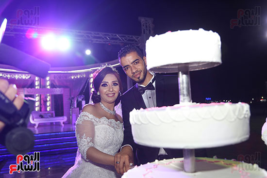 العروسان مصطفى وولاء خلال تقطيع تورته حفل الزفاف 