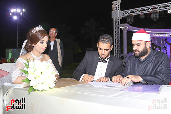 العروسان خلال توقيع عقد القران 