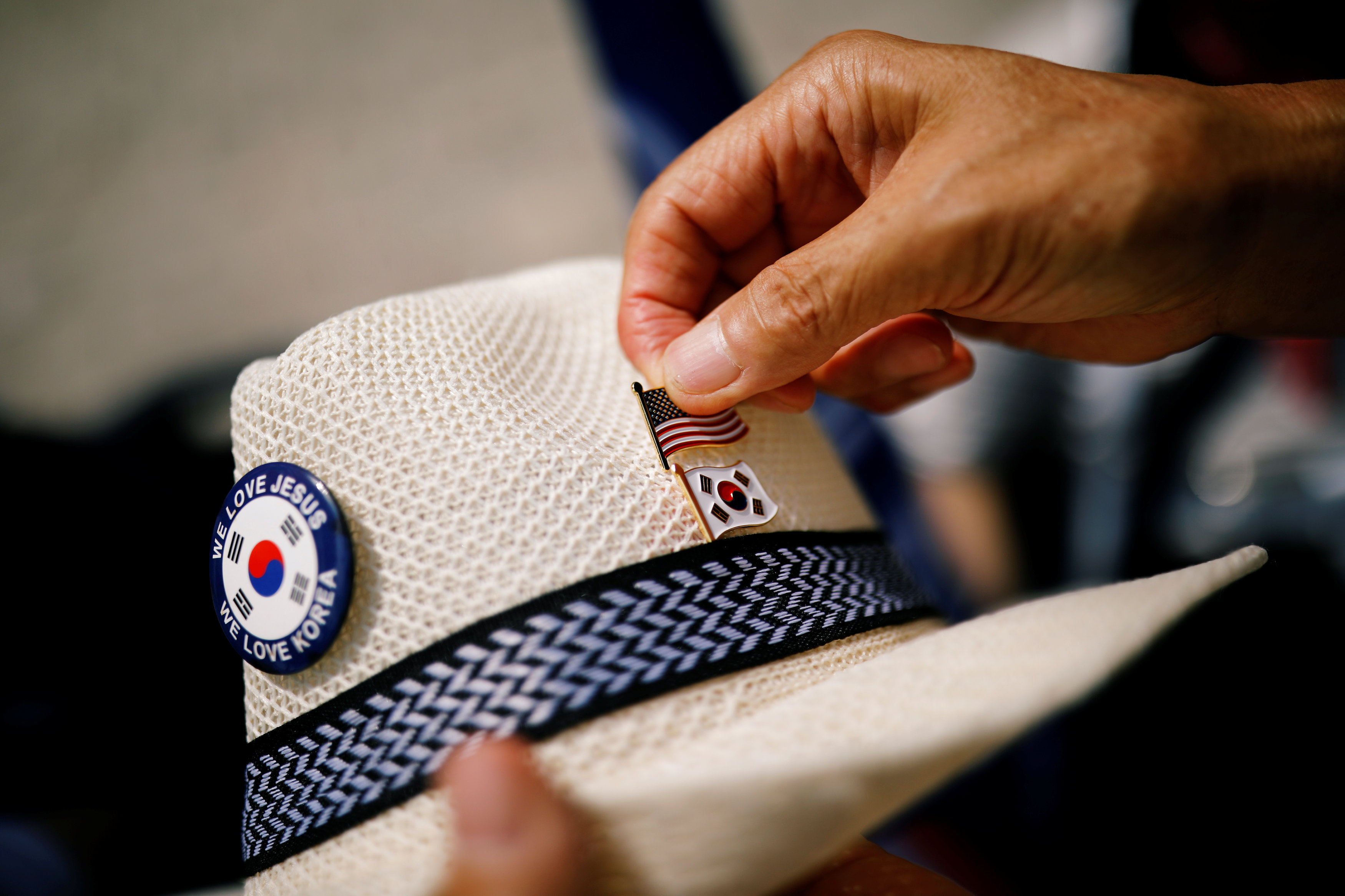 متظاهر يضع العلم الأمريكى بجوار علم كوريا الجنوبية على قبعته