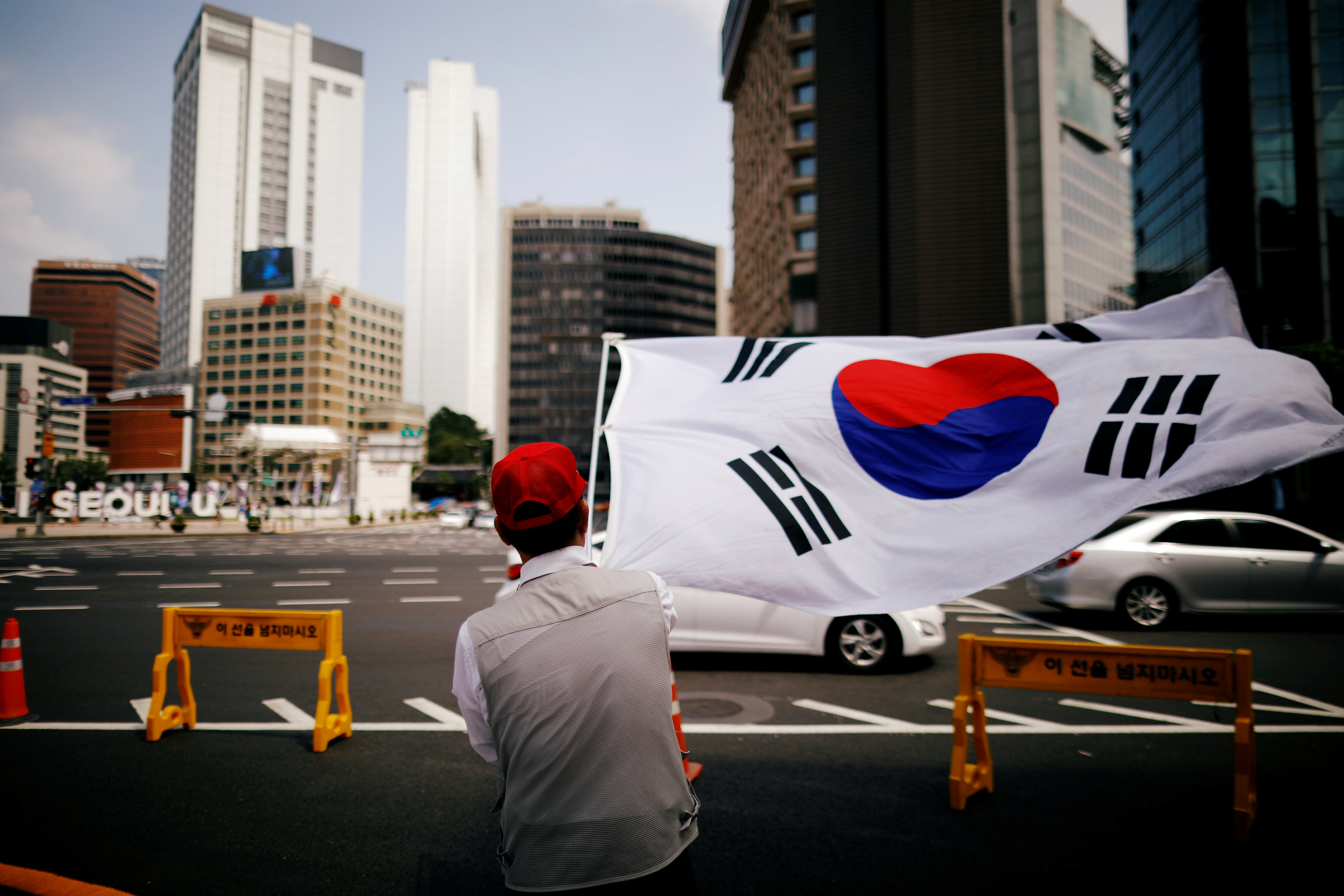 احد المتظاهرين يلوح بعلم كوريا الجنوبية