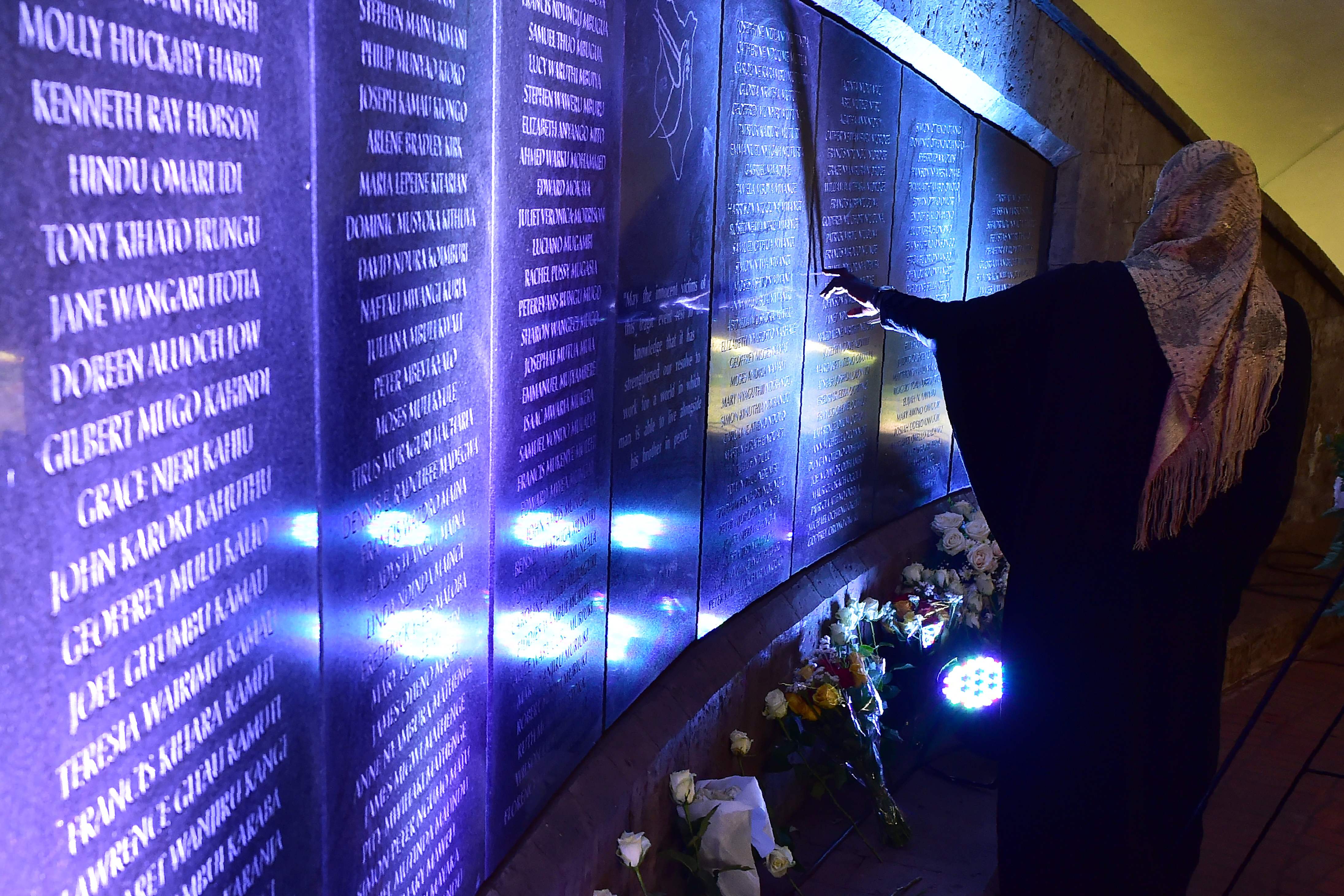 مواطنة أمام النصب التذكارى الذى يحمل أسماء ضحايا الهجوم
