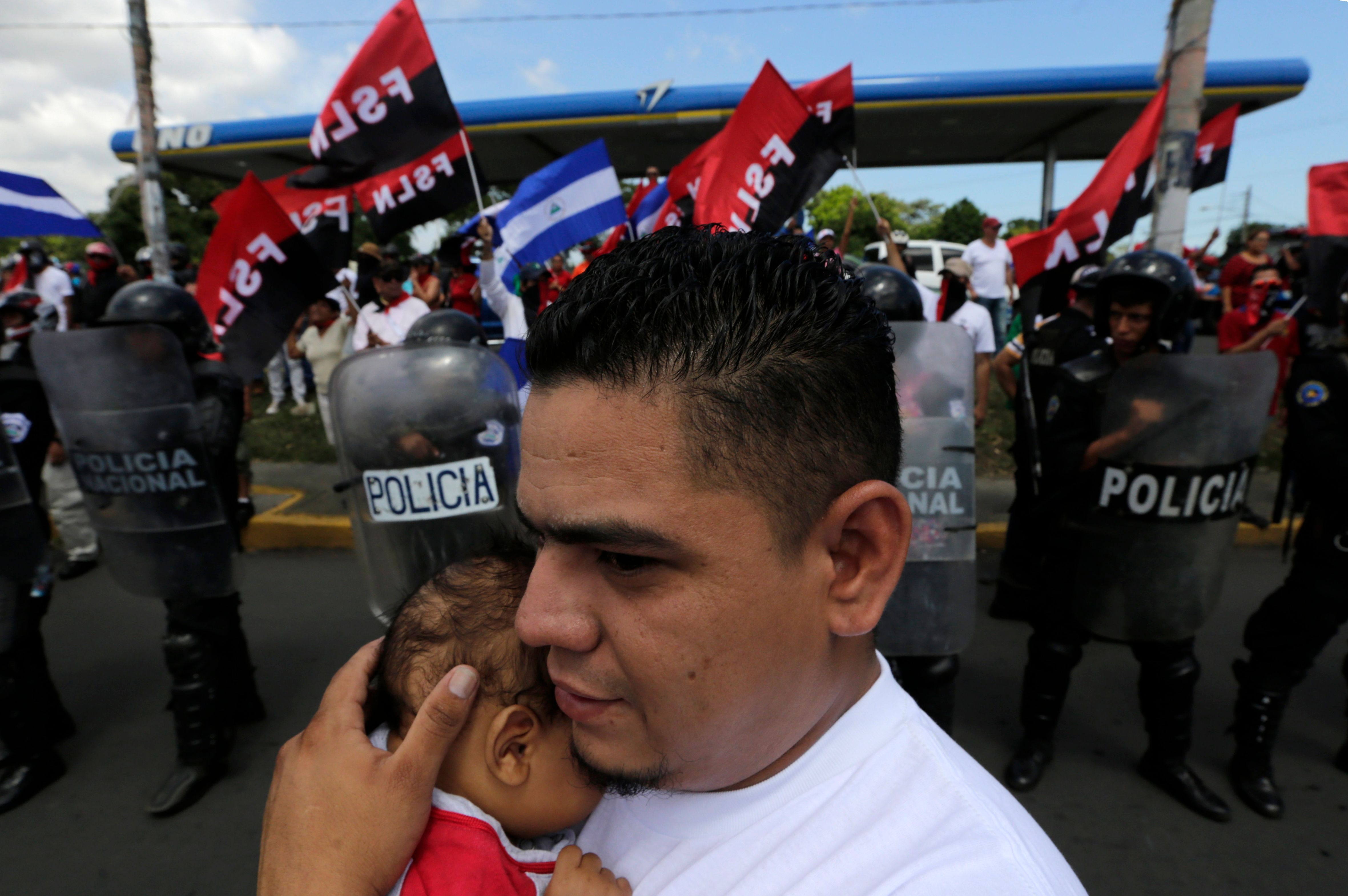 رجل يحمل طفل خلال الاحتجاجات