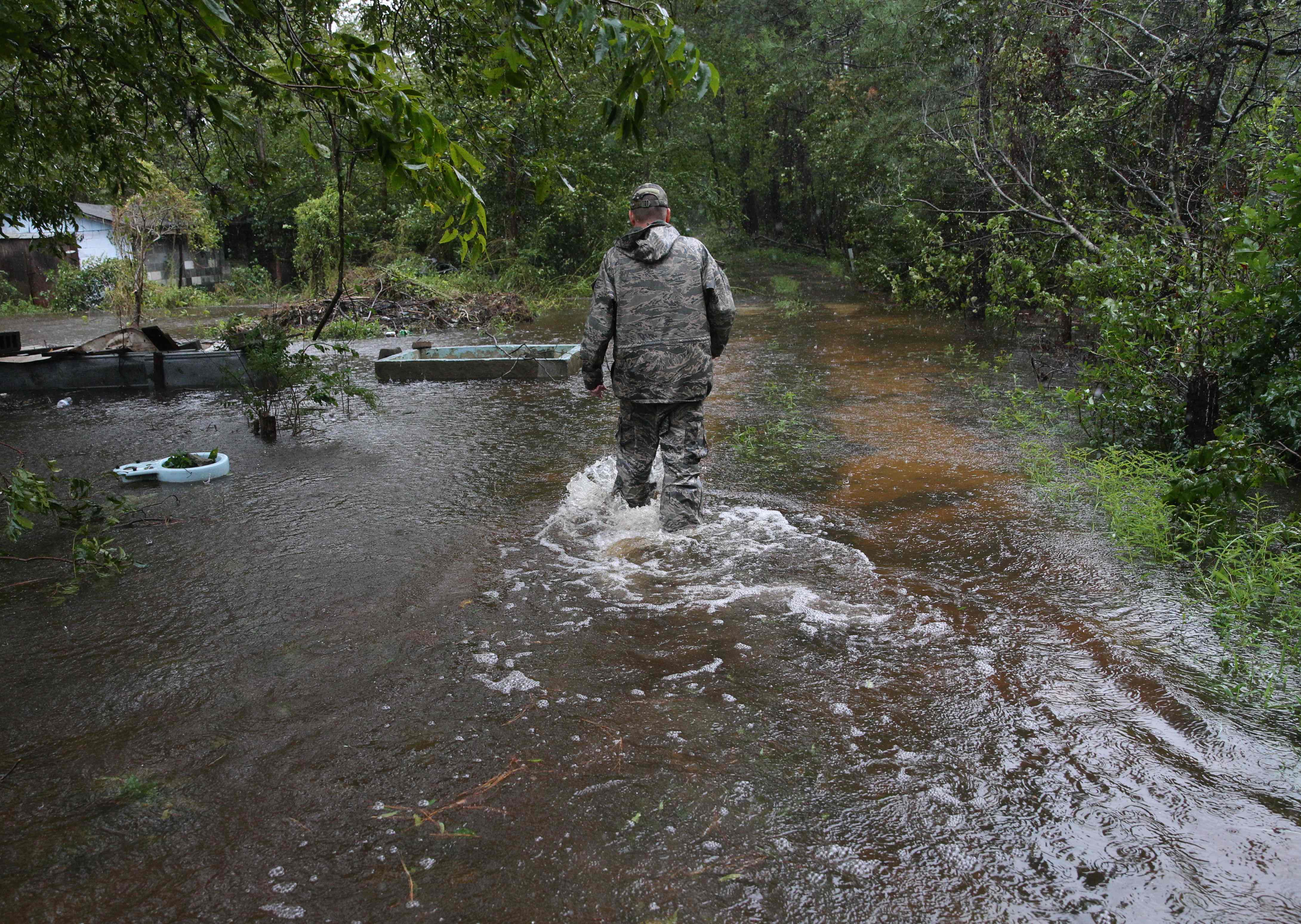 أحد رجال الانقاذ يسير وسط مياه الامطار